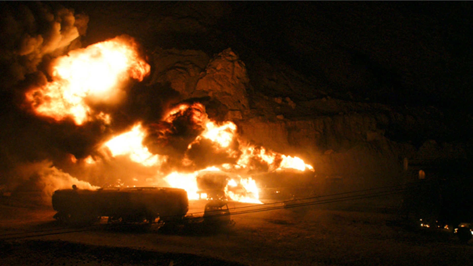 May 31: Afghanistan-bound NATO tankers shoot flames and smoke into the sky after being set on fire.