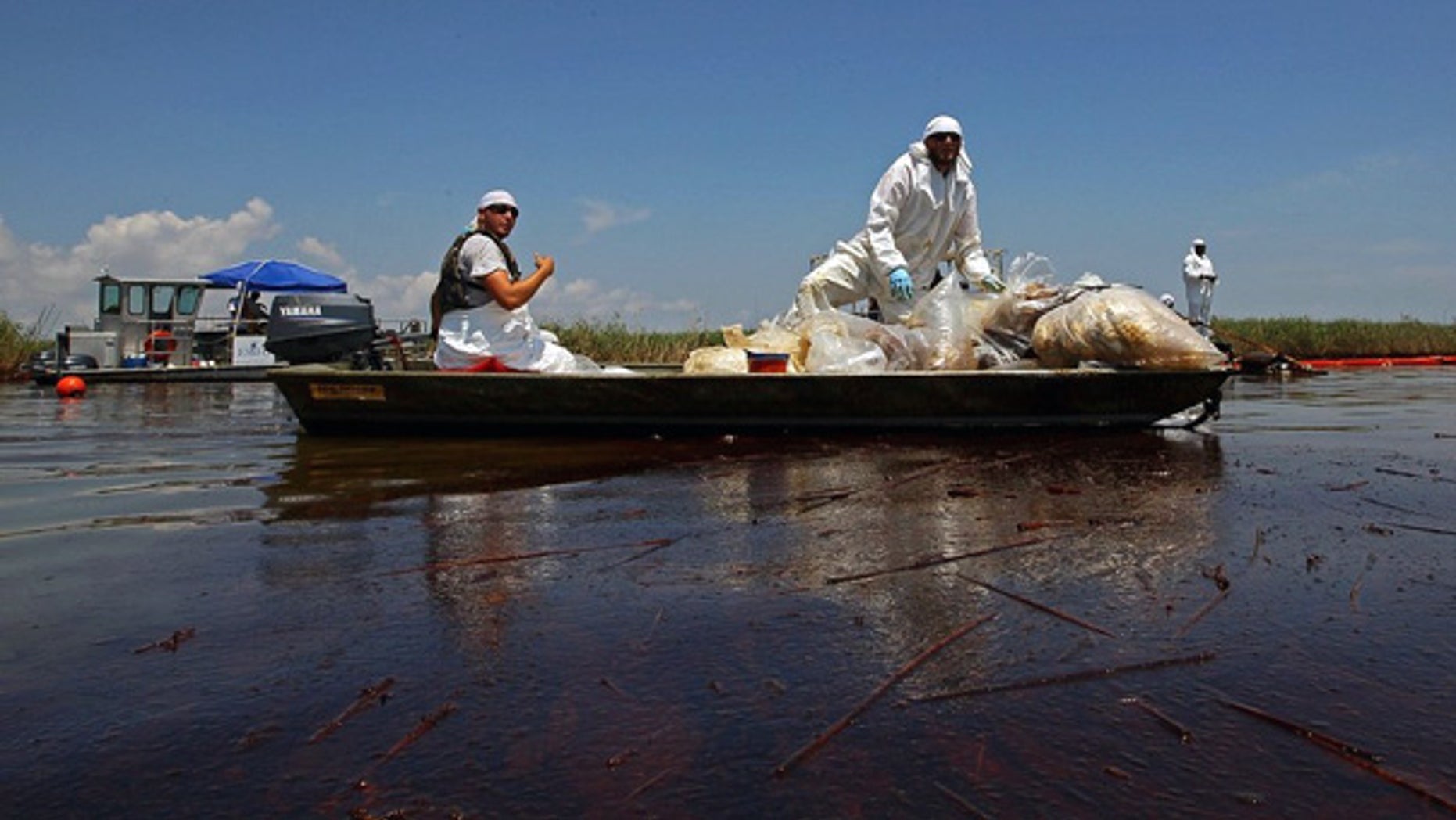 June 1: Contract workers from BP ferry oil-soaked waste in a marsh near Pass a Loutre, La.