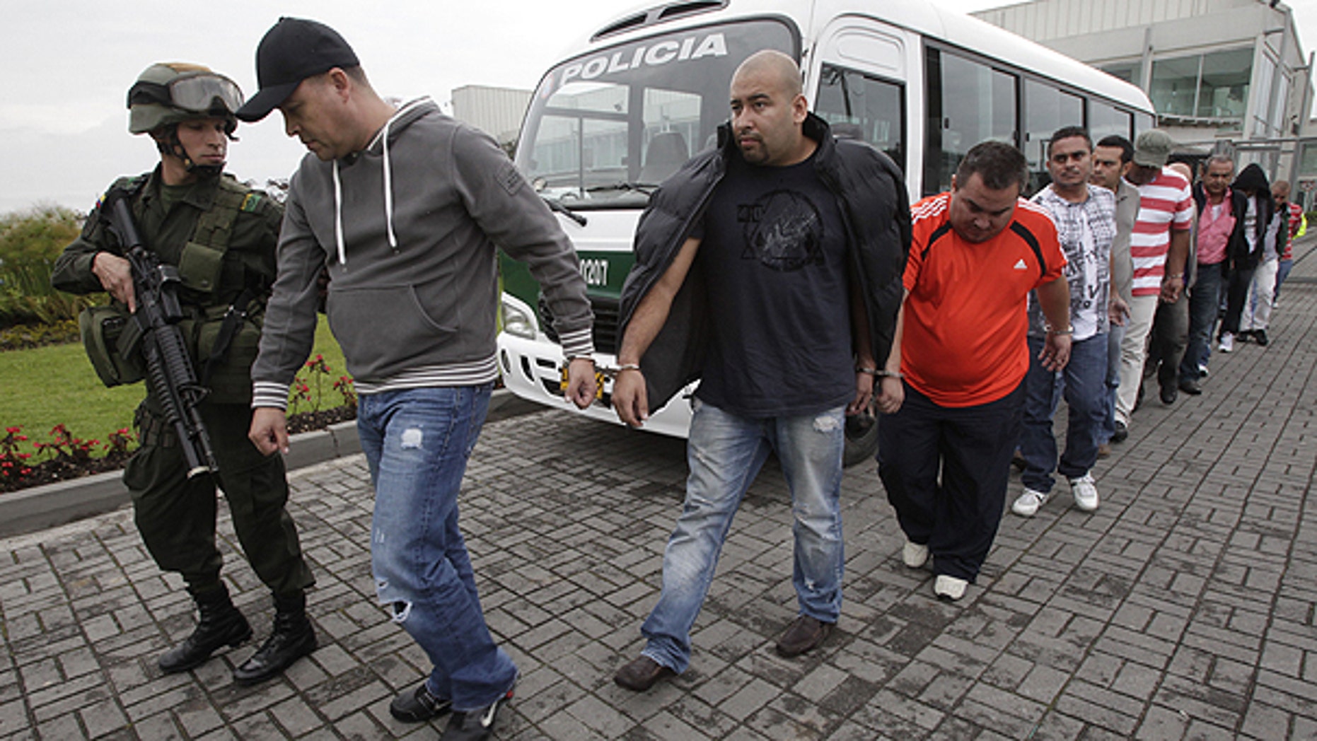 June 2: Police officers escort alleged drug traffickers at a police station in Bogota. After a five year joint investigation that began in Boston, between the Colombian and Italian police as well as the U.S. Drug Enforcement Administration, DEA, a total of twenty men, twelve in Colombia, were arrested for allegedly conspiring to smuggle cocaine and heroin, police said.