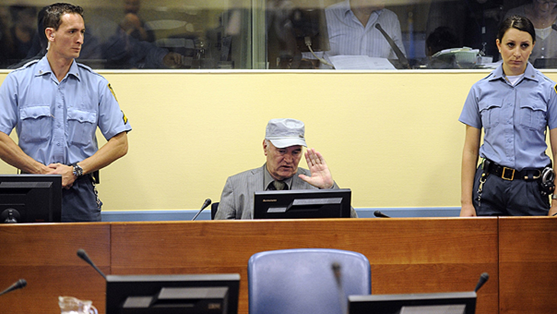June 3: Former Bosnian Serb Gen. Ratko Mladic, center, salutes between officers standing guard in the court room during his initial appearance at the U.N.'s Yugoslav war crimes tribunal in The Hague, Netherlands.