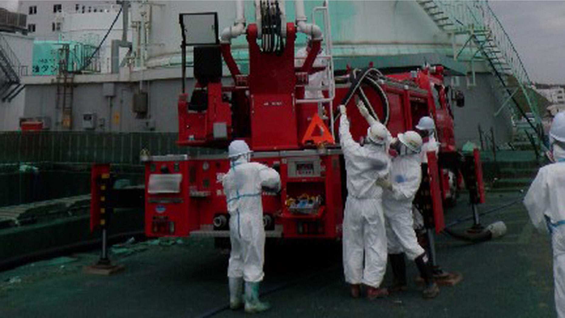 May 27: Workers spray a substance to prevent radioactive materials from spreading out from the Unit 1 area at the Fukushima Dai-ichi nuclear complex in Okuma, Fukushima Prefecture, northeastern Japan.
