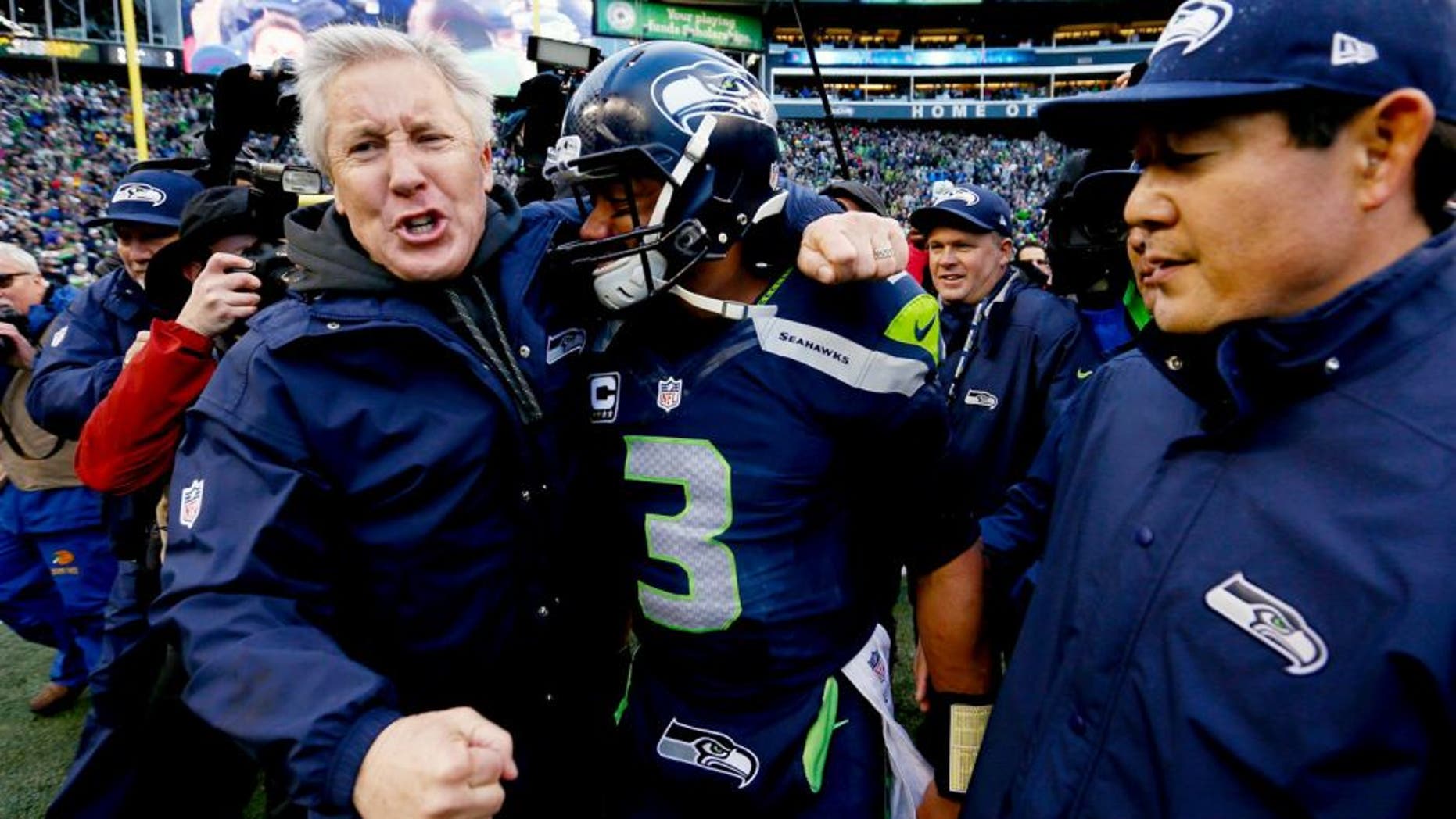 SEATTLE, WA - JANUARY 18: Head coach Pete Carroll and Russell Wilson #3 of the Seattle Seahawks celebrate after the Seahawks 28-22 victory in overtime against the Green Bay Packers during the 2015 NFC Championship game at CenturyLink Field on January 18, 2015 in Seattle, Washington. (Photo by Kevin C. Cox/Getty Images)
