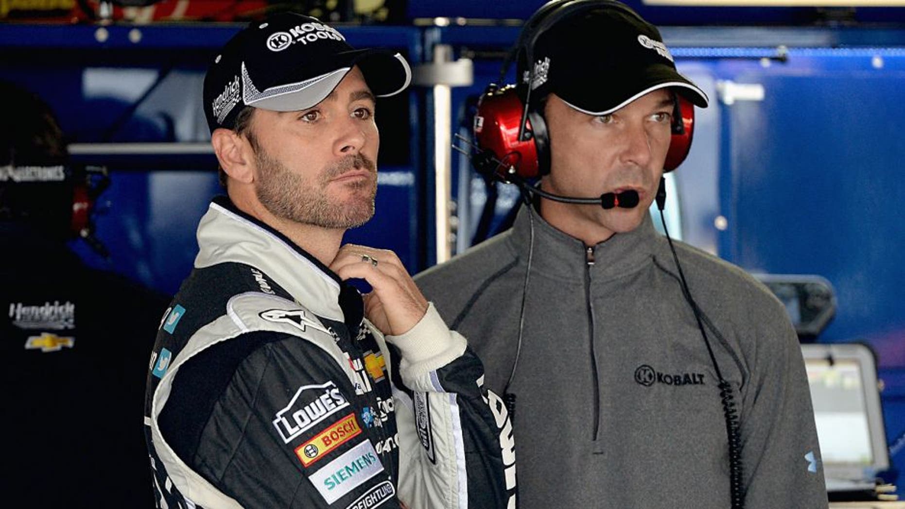 DOVER, DE - MAY 30: Jimmie Johnson, left, driver of the #48 Lowe's/Kobalt Tools Chevrolet, and crew chief Chad Knaus looks on in the garage area during practice for the NASCAR Sprint Cup Series FedEx 400 Benefiting Autism Speaks at Dover International Speedway on May 30, 2014 in Dover, Delaware. (Photo by Patrick Smith/Getty Images)