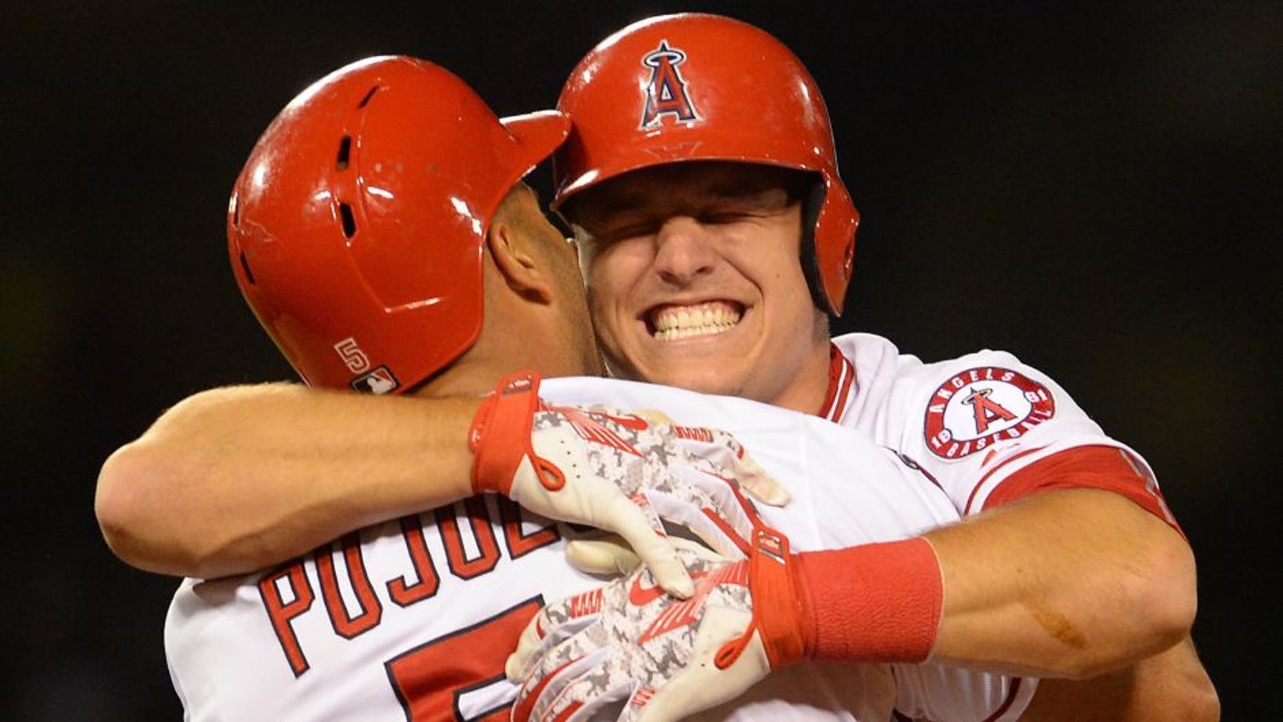 May 13, 2015; Anaheim, CA, USA; Los Angeles Angels center fielder Mike Trout (27) hugs first baseman Albert Pujols (5) after Pujols hit a game winning sacrifice fly ball in the eleventh inning of the game against the Colorado Rockies at Angel Stadium of Anaheim. Angels won 2-1. Mandatory Credit: Jayne Kamin-Oncea-USA TODAY Sports