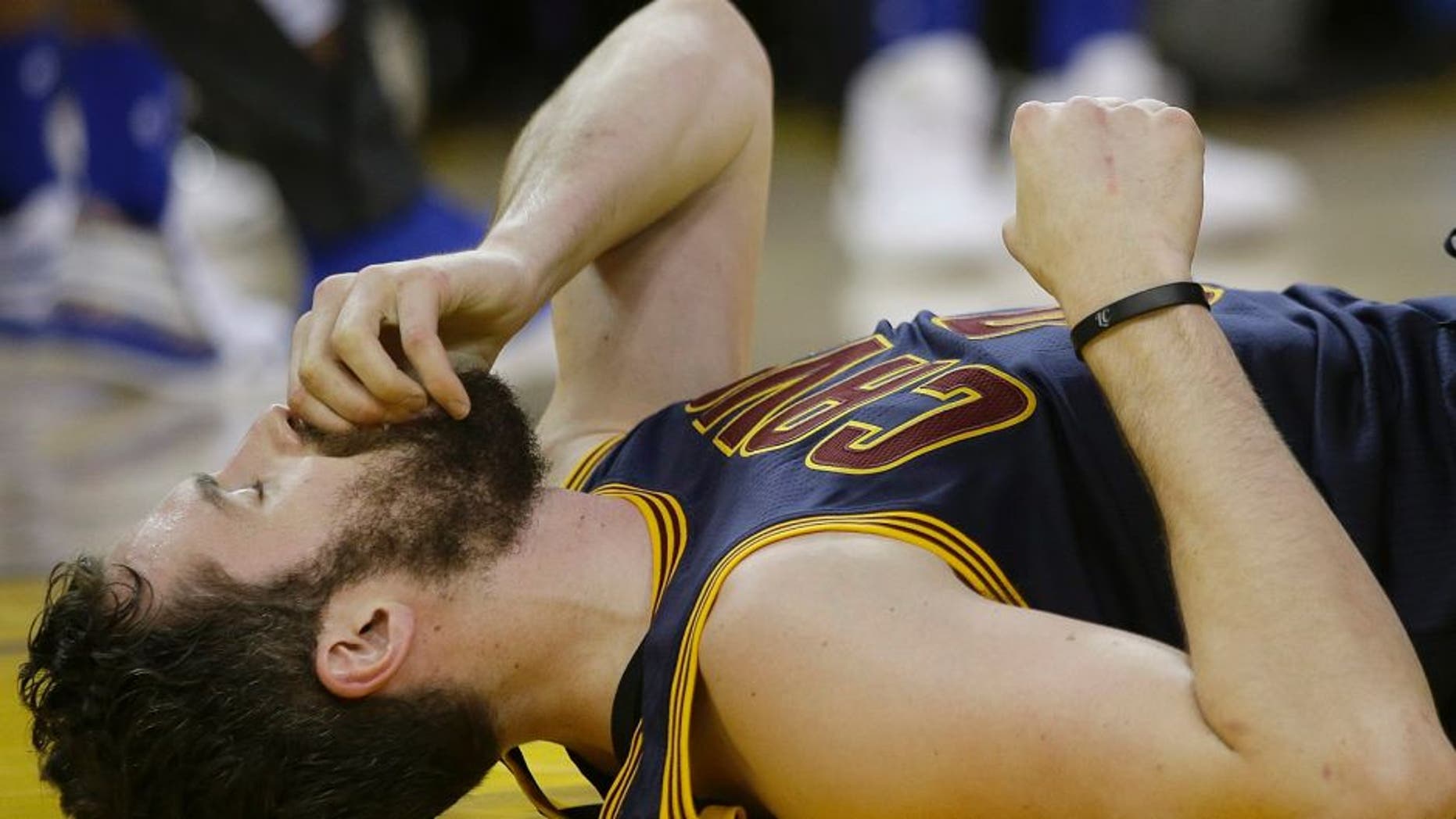 Cleveland Cavaliers forward Kevin Love remains on the floor after a play during the first half of Game 2 of basketball's NBA Finals between the Golden State Warriors and the Cavaliers in Oakland, Calif., Sunday, June 5, 2016. (AP Photo/Marcio Jose Sanchez)