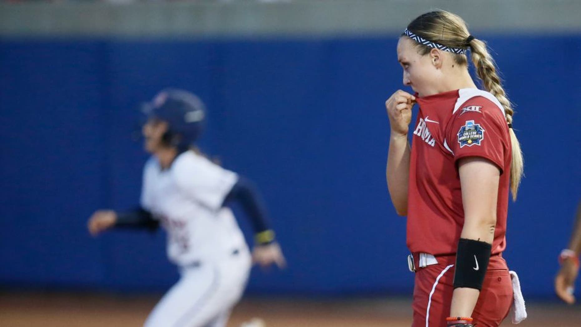 Oklahoma pitcher Jayden Chestnut, right, watches as Auburn's Kasey Cooper rounds the bases on her two-run home run in the fourth inning of the second game of the best-of-three championship series in the NCAA softball Women's College World Series in Oklahoma City, Tuesday, June 7, 2016. (AP Photo/Sue Ogrocki)