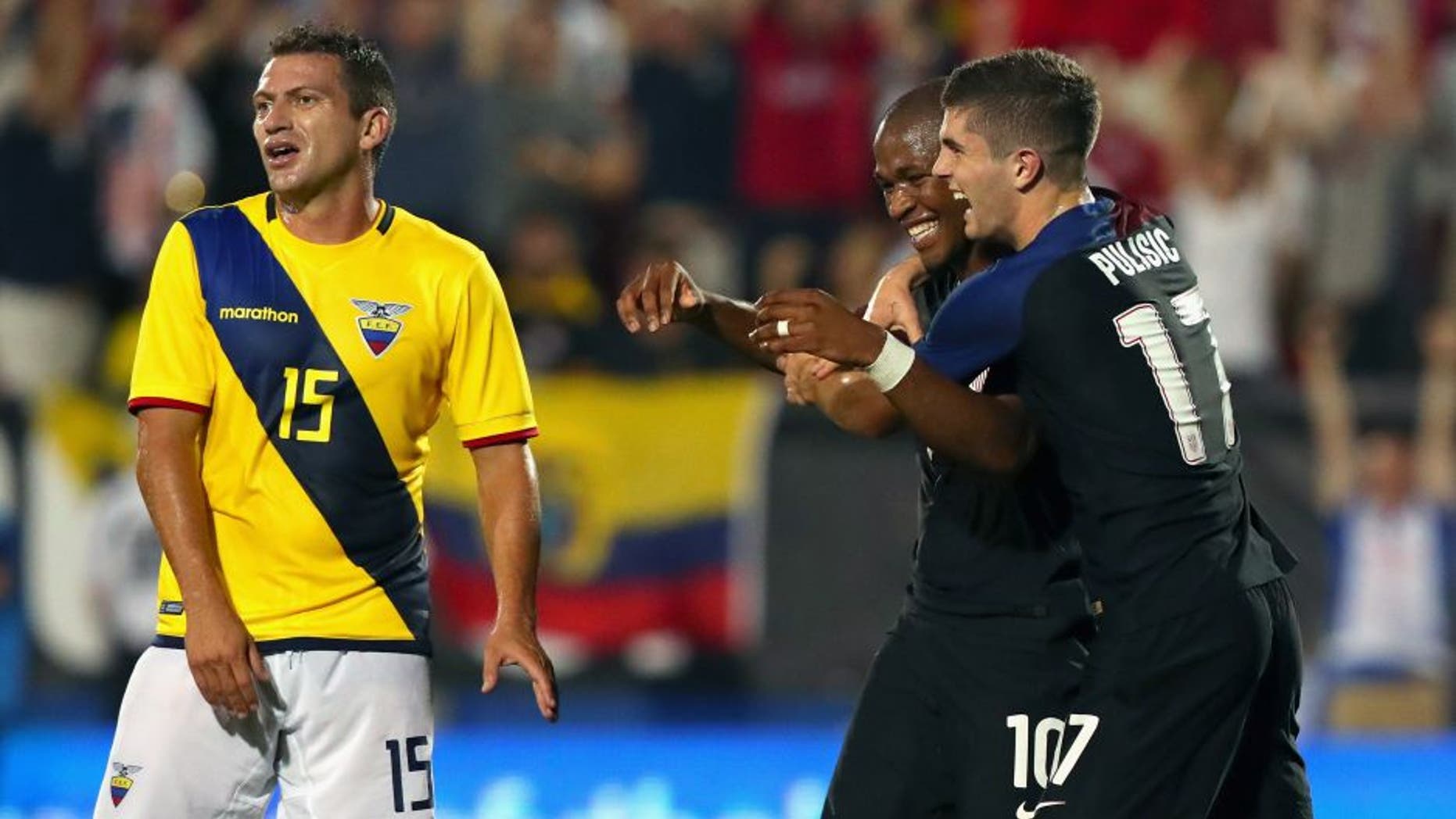 FRISCO, TX - MAY 25: Pedro Larrea #15 of Ecuador reacts as Darlington Nagbe #10 of the United States celebrates with Christian Pulisic #17 of the United States after scoring against Ecuador during an International Friendly match at Toyota Stadium on May 25, 2016 in Frisco, Texas. (Photo by Tom Pennington/Getty Images)