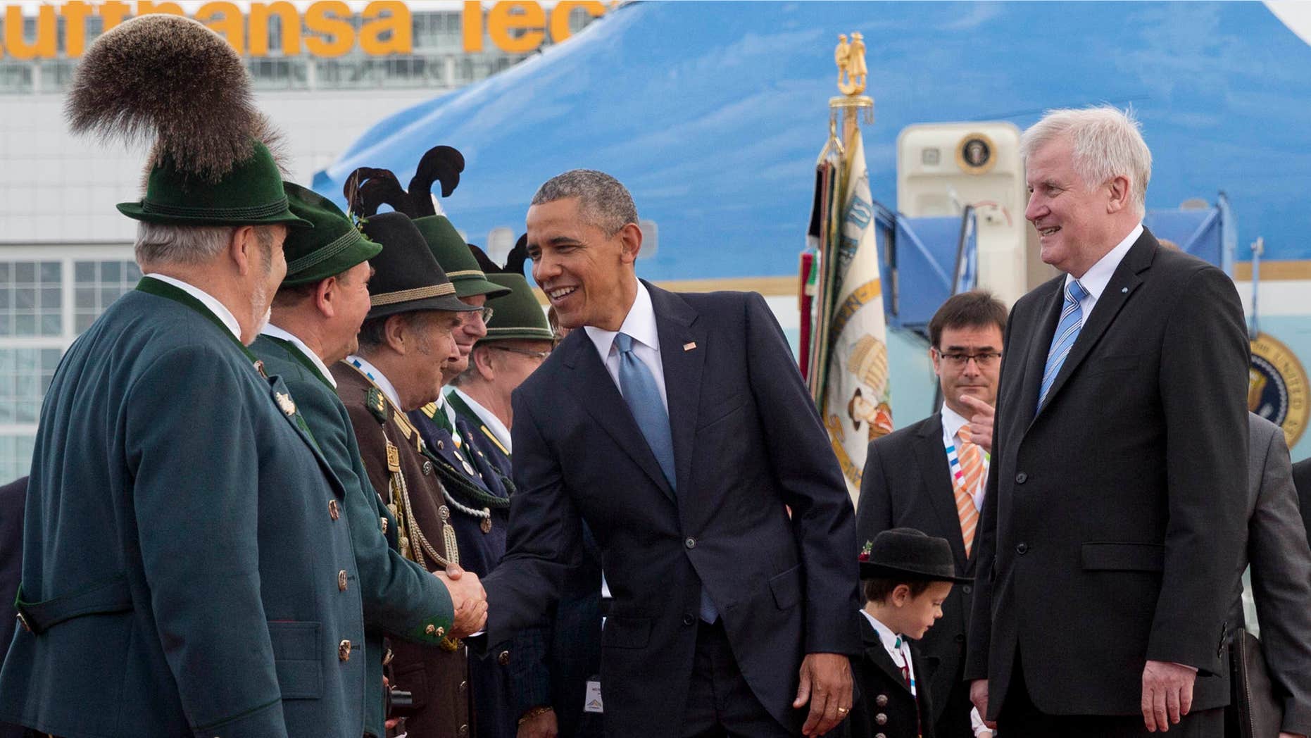 June 7, 2015: US President Barack Obama, joined by Horst Seehofer, Minister President of Bavaria, right, is greeted by traditionally dressed Bavarian men and women as he arrives on Air Force One at the airport in Munich, southern Germany.