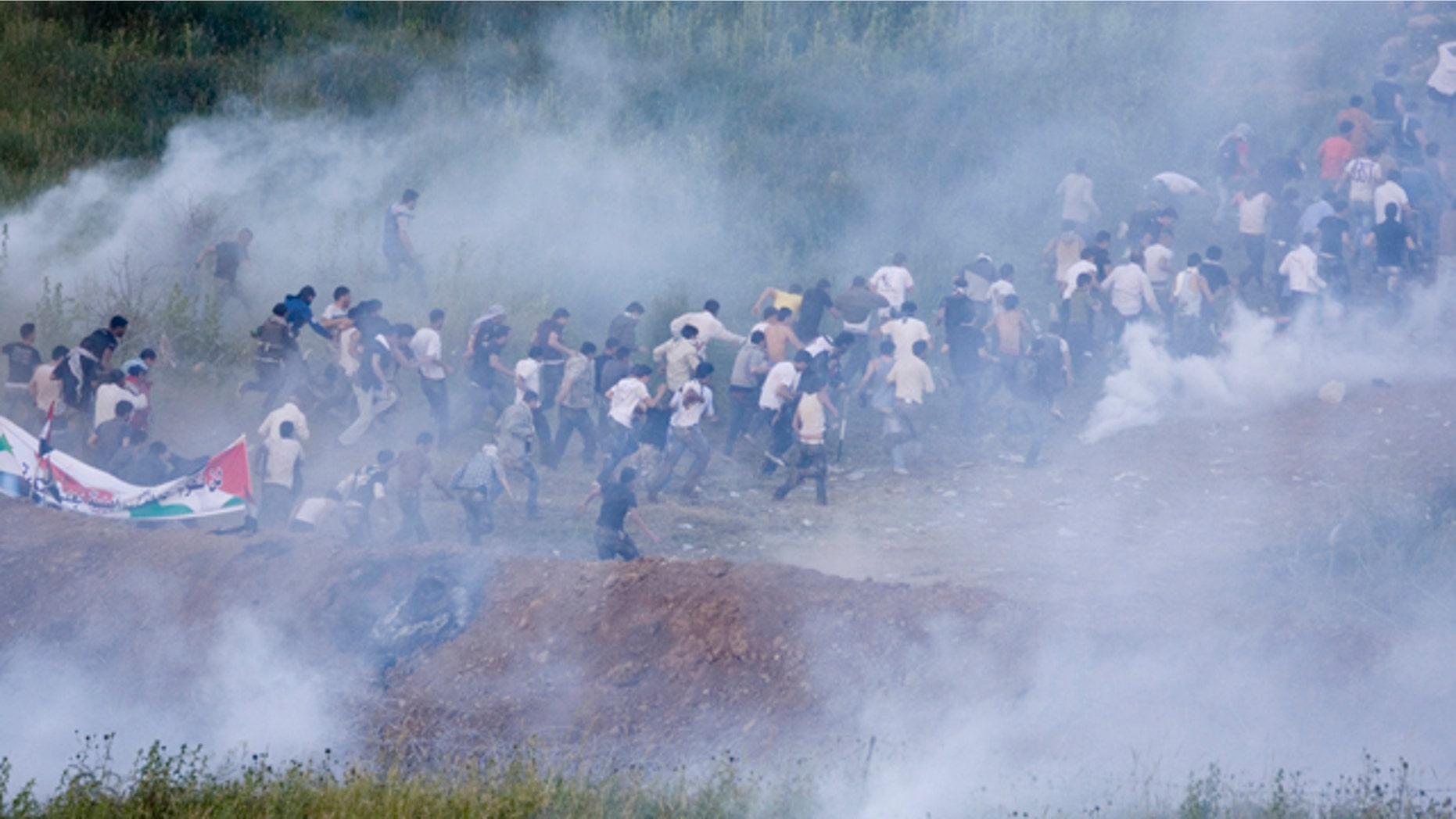 June 5: Pro-Palestinian protesters run from tear gas fired by Israeli troops along the border between Israel and Syria near the village of Majdal Shams in the Golan Heights.