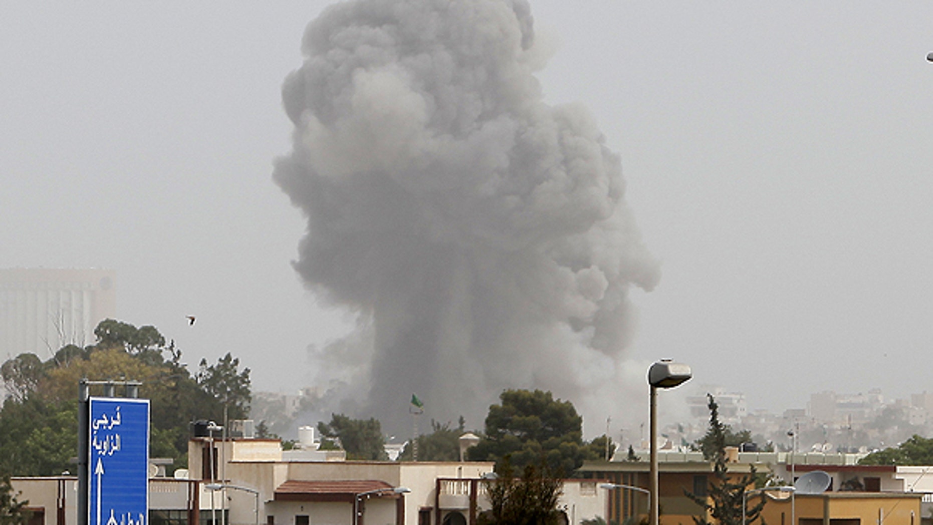 June 7: A smoke and dust cloud from an explosion rises into the sky after a NATO airstrike in Tripoli, Libya.