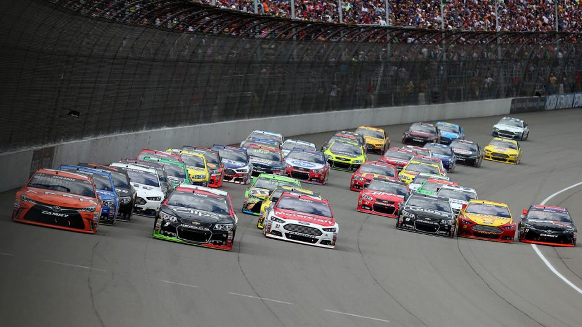 BROOKLYN, MI - JUNE 14: Carl Edwards, driver of the #19 ARRIS Toyota, Kasey Kahne, driver of the #5 Great Clips Chevrolet, and Ryan Blaney, driver of the #21 Motorcraft/Quick Lane Tire & Auto Center Ford, lead the field into turn one after a restart during the NASCAR Sprint Cup Series Quicken Loans 400 at Michigan International Speedway on June 14, 2015 in Brooklyn, Michigan. (Photo by Brian Lawdermilk/Getty Images)