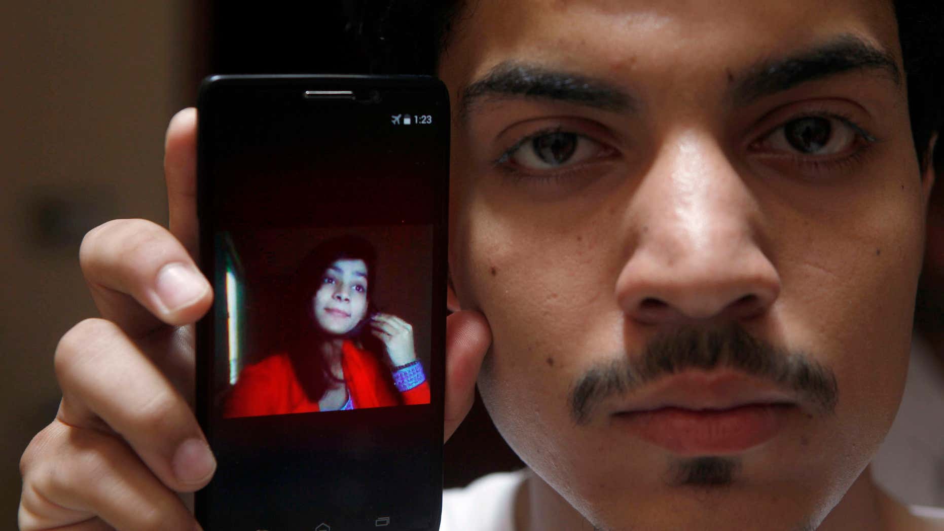 June 8, 2016: Hassan Khan shows the picture of his wife Zeenat Rafiq, who was burned alive, allegedly by her mother, on a mobile phone at his home in Lahore, Pakistan.