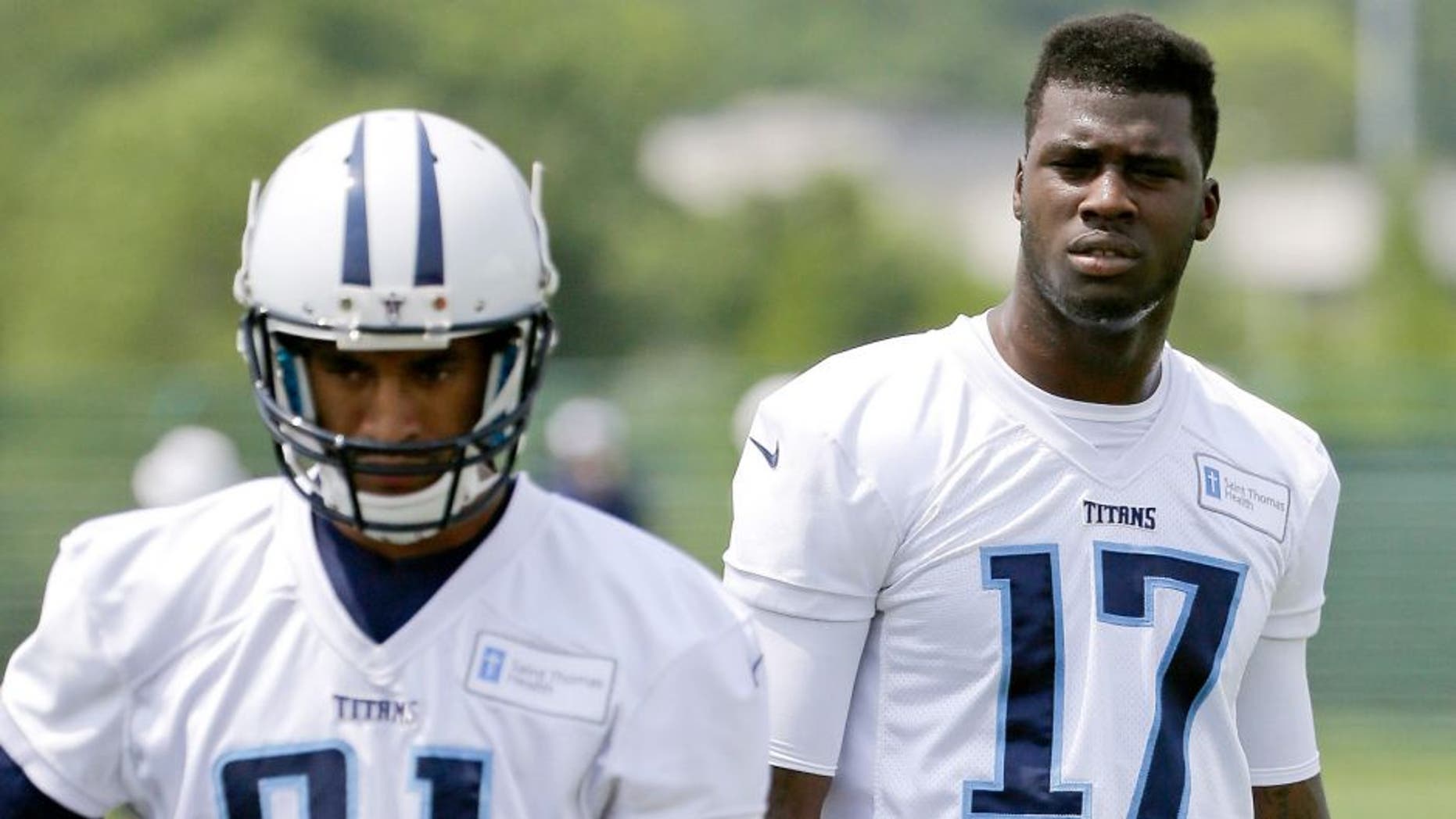 Tennessee Titans wide receivers Dorial Green-Beckham (17) and Rico Richardson (81) watch teammates run a drill during an organized team activity at the team's NFL football training facility Monday, June 8, 2015, in Nashville, Tenn. An aggravated hamstring has limited Green-Beckham, who is working to reform his image after off-field issues dropped him into the second round of the draft. (AP Photo/Mark Humphrey)