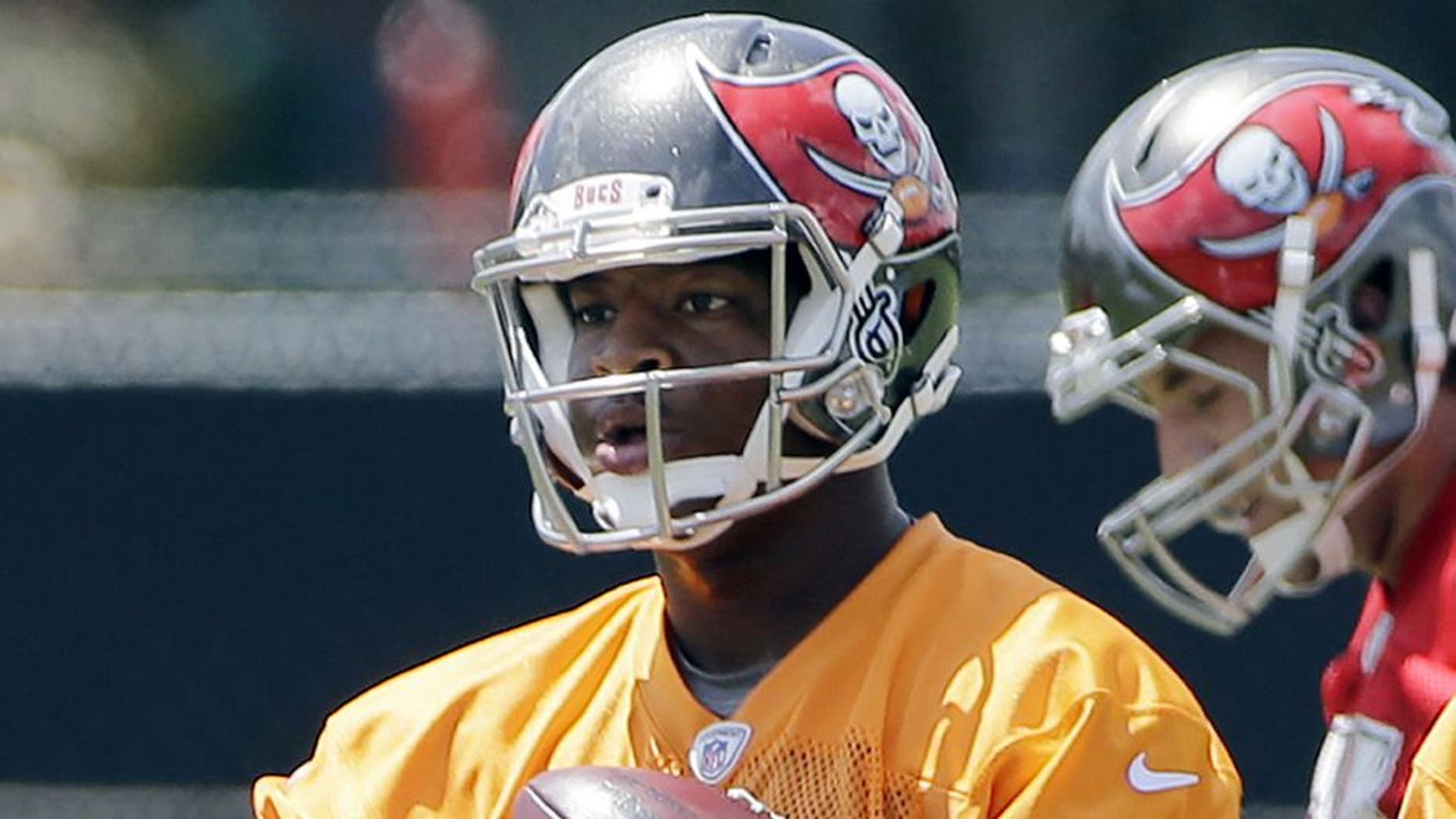 Tampa Bay Buccaneers quarterback Jameis Winston carries a handful of footballs during an NFL football organized team activity, Thursday, June 4, 2015, in Tampa, Fla. (AP Photo/Chris O'Meara)
