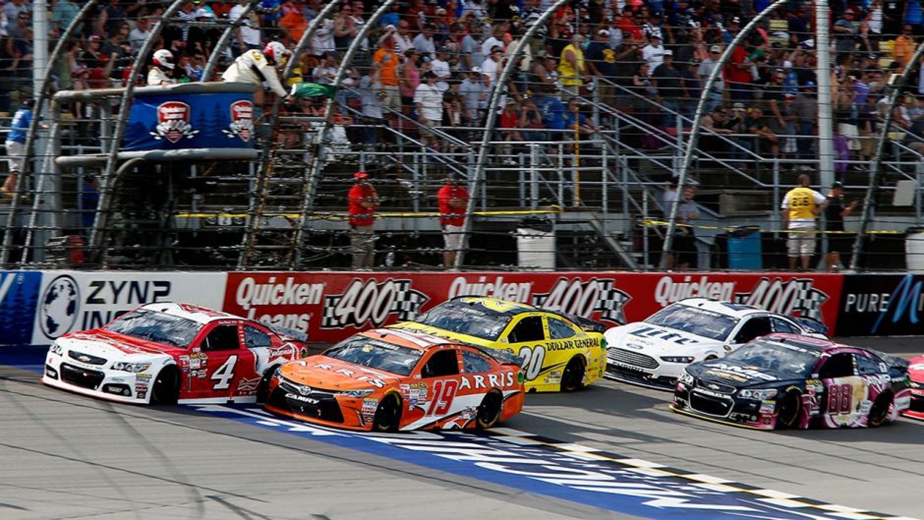 BROOKLYN, MI - JUNE 14: Carl Edwards, driver of the #19 ARRIS Toyota, and Kevin Harvick, driver of the #4 Budweiser/Jimmy John's Chevrolet, lead the field to a restart during the NASCAR Sprint Cup Series Quicken Loans 400 at Michigan International Speedway on June 14, 2015 in Brooklyn, Michigan. (Photo by Jerry Markland/Getty Images)