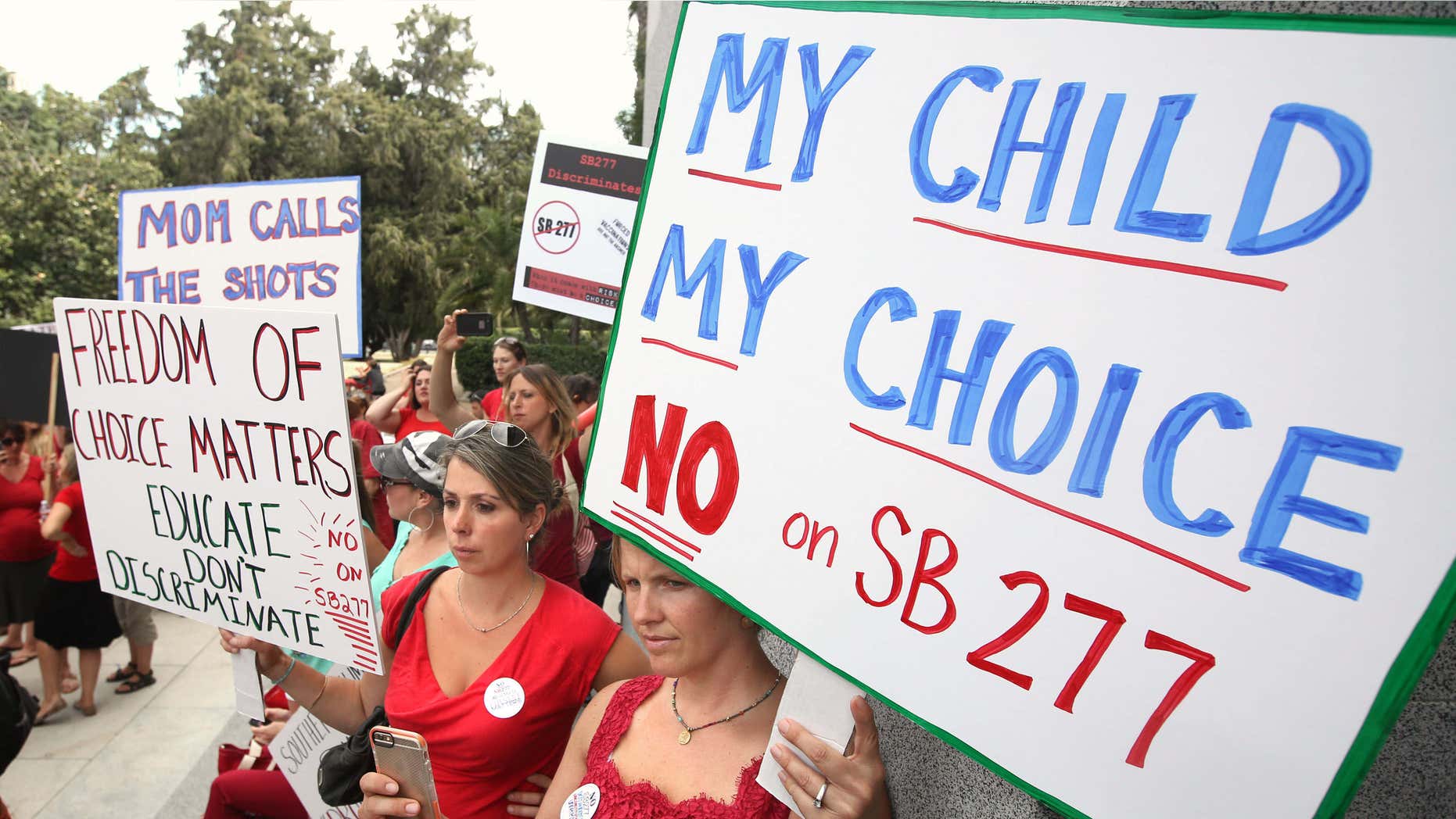 June, 2015: Karman Willmer, left, and Shelby Messenger protest against SB277, a measure requiring California schoolchildren to get vaccinated, at a Capitol rally.