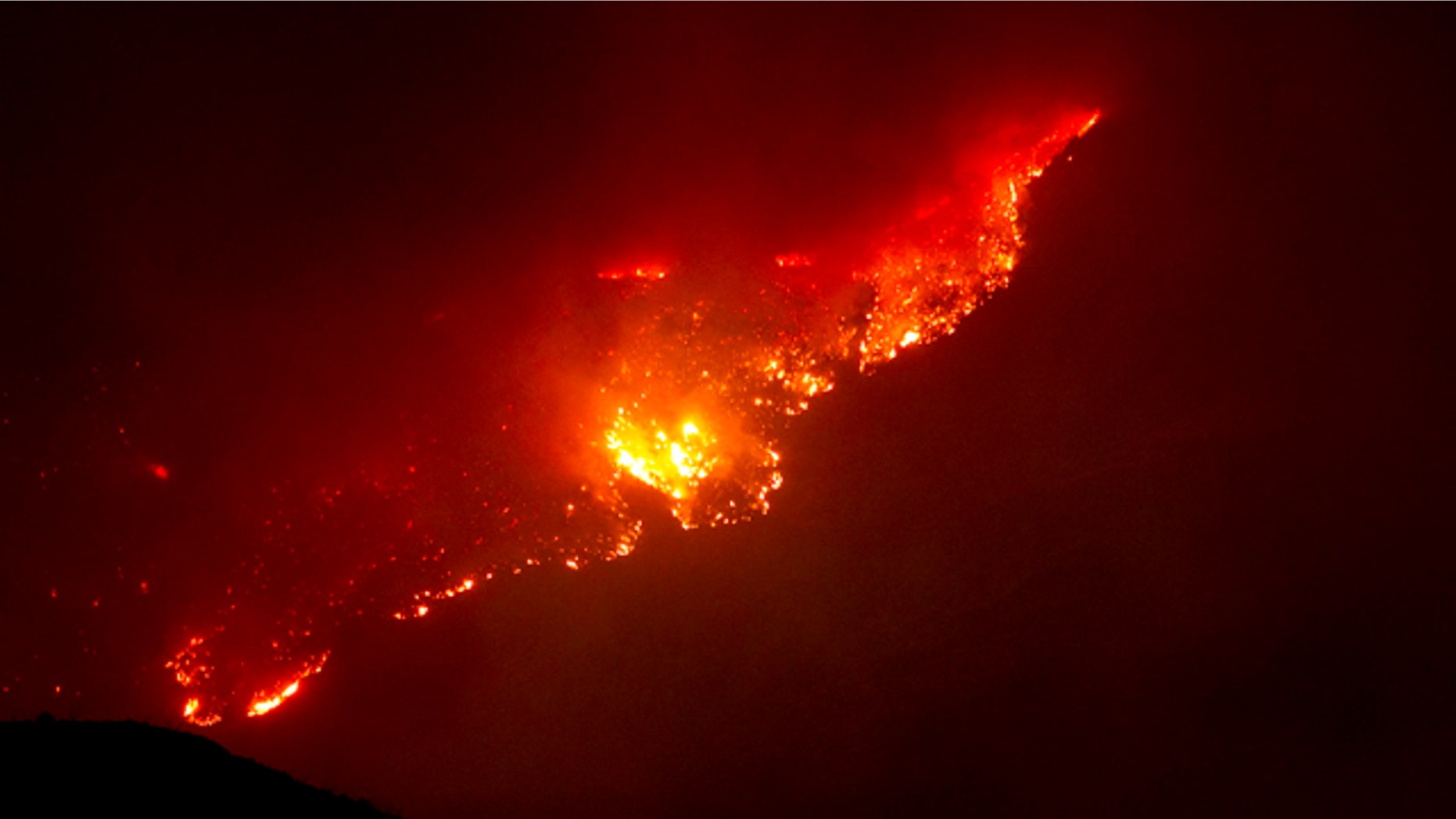 June 8: A mountain top glows from the Horseshoe Two fire near Paradise and Portal, Ariz.