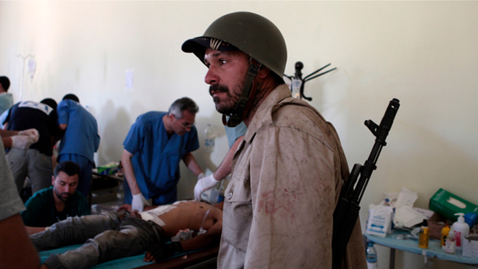 June 10: A Libyan rebel fighter arrives at a hospital as others receive treatment in Misrata, Libya.