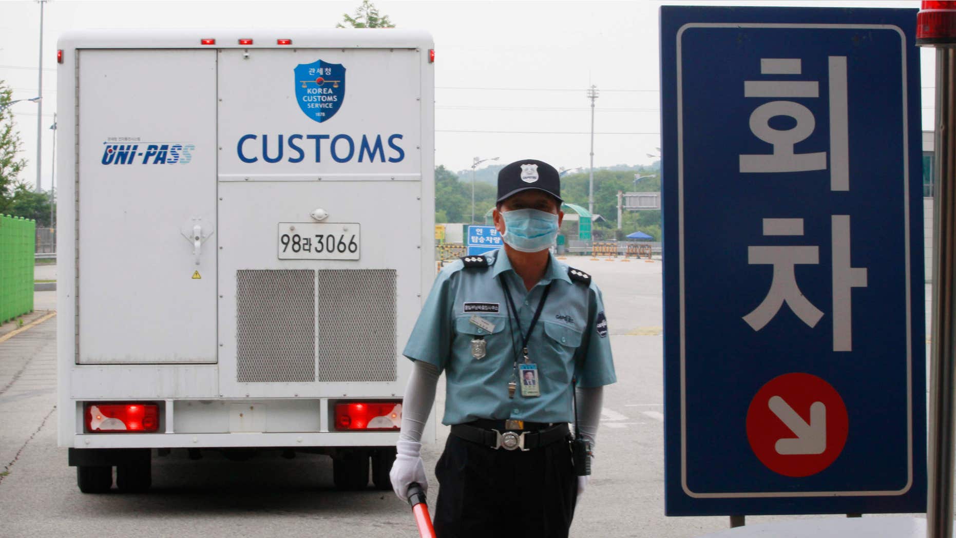 June 13, 2015: A South Korean security person wears a mask as a precaution against the Middle East Respiratory Syndrome (MERS) virus at the customs, immigration and quarantine gate in Paju, South Korea, near the border village of Panmunjom, South Korea.
