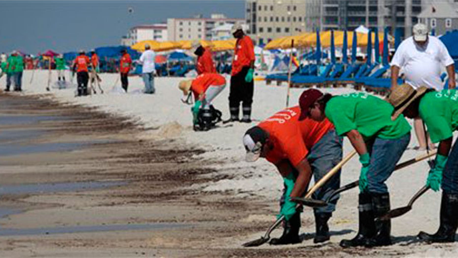 June 12: Oil cleanup workers hired by BP clean oily deposits from the shore in Orange Beach, Ala.
