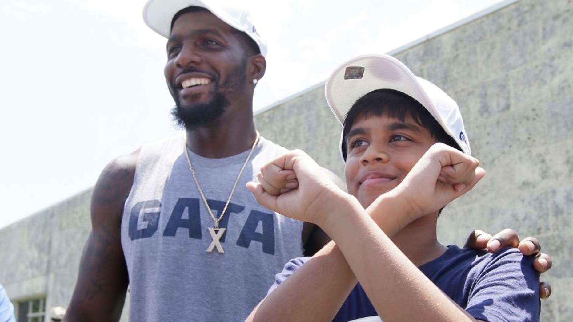 Dallas Cowboys wide receiver Dez Bryant, left, stands by as 11-year-old spelling bee champion Nahir Janga of Austin, throws up a celebratory 'X' at the NFL football team's minicamp at Valley Ranch in Irving, Texas, Wednesday, June 15, 2016. Janga was on hand to visit with the Cowboys and meet Bryant who inspired him to throw up an 'X' when he won the spelling bee. (AP Photo/LM Otero)