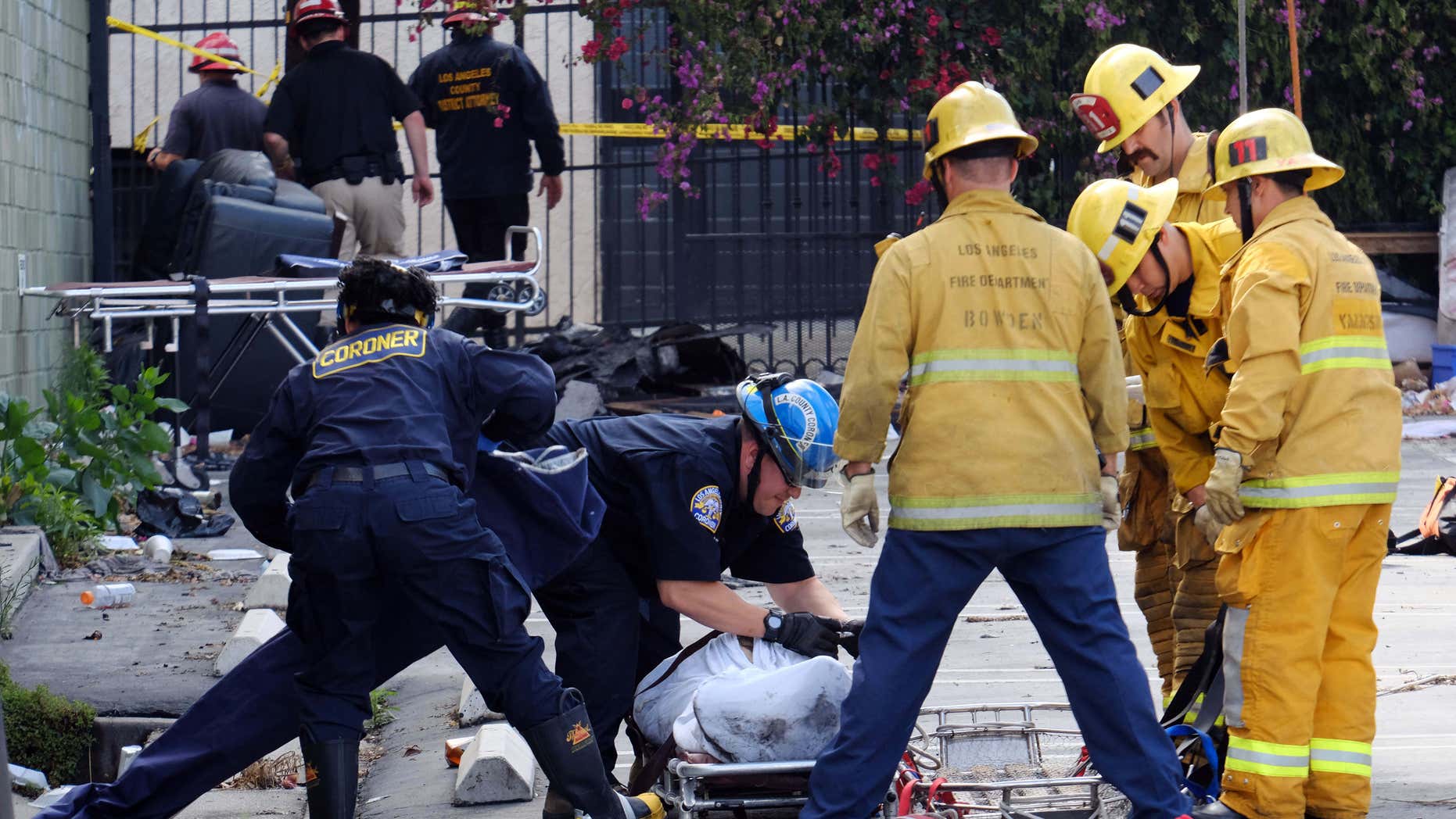 June 14, 2016: Coroner's officials and firefighters prepare to move one of four bodies found in the burned-out ruins of a abandoned office building in the Westlake district just west of downtown Los Angeles.