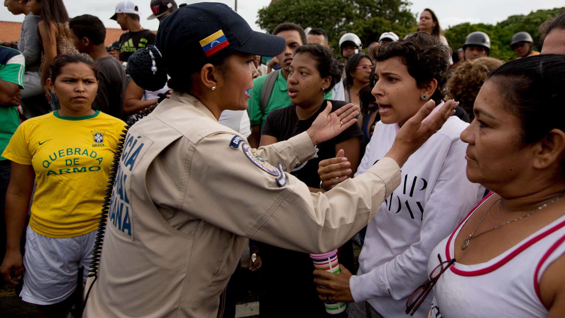 June 14, 2016: A police officer talks to an angry crowd during a protest for food at the Catia neighborhood in Caracas, Venezuela.