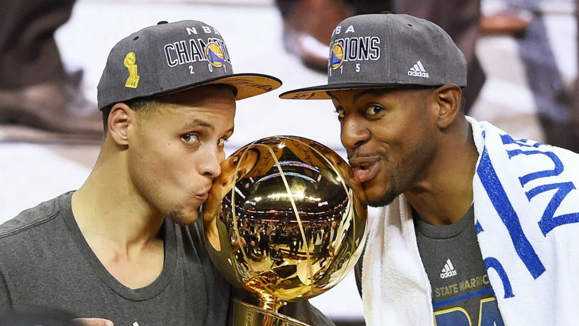 Stephen Curry #30 and Andre Iguodala #9 of the Golden State Warriors celebrate with the Larry O'Brien NBA Championship Trophy after defeating the Cleveland Cavaliers in Game Six of the 2015 NBA Finals at Quicken Loans Arena on June 16, 2015 in Cleveland, Ohio. NOTE TO USER: User expressly acknowledges and agrees that, by downloading and or using this photograph, user is consenting to the terms and conditions of Getty Images License Agreement. (Photo by Jason Miller/Getty Images)