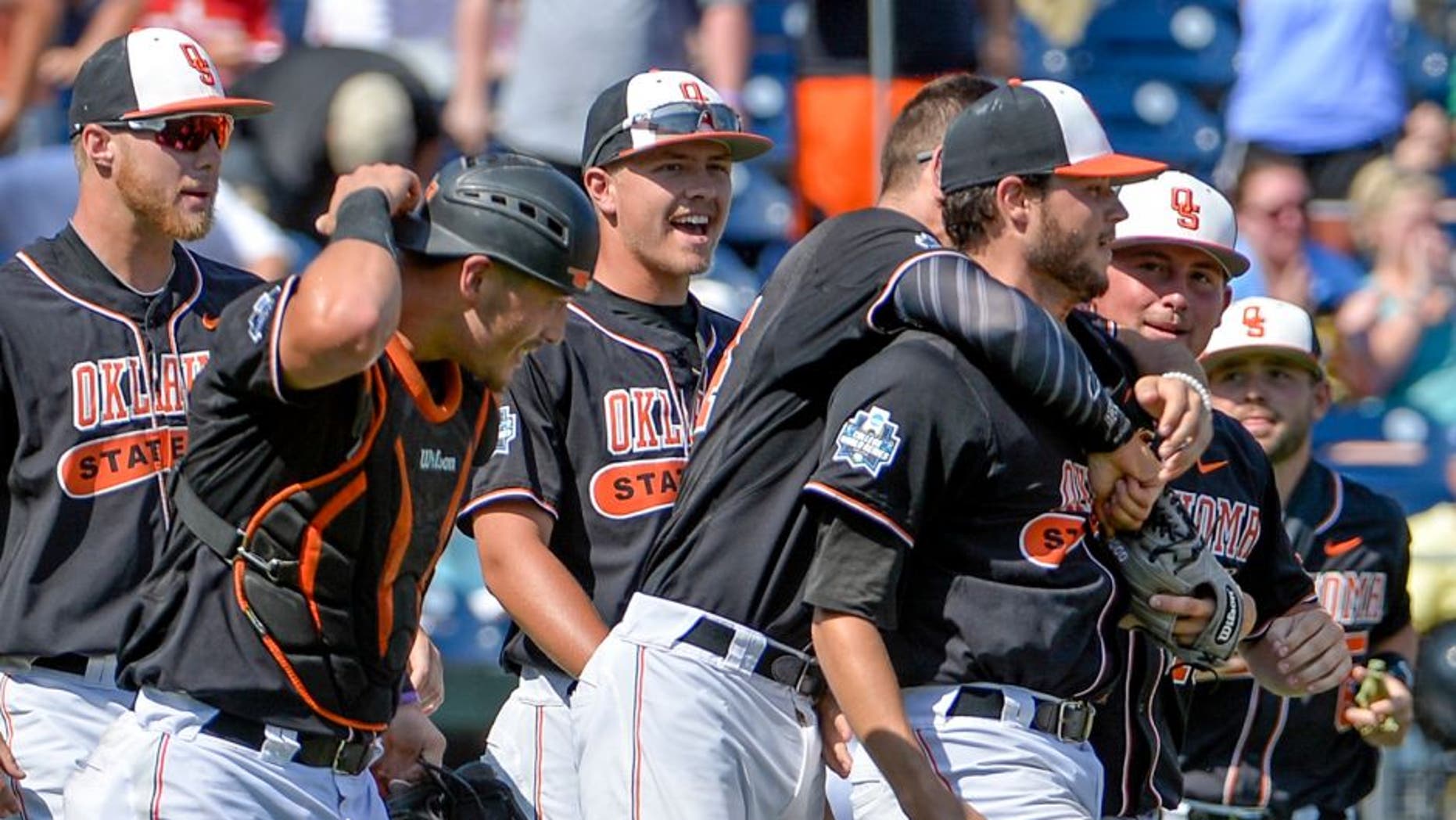 Oklahoma State starting pitcher Thomas Hatch, third from right, is congratulated by teammates after the last out of an NCAA men's College World Series baseball game against UC Santa Barbara in Omaha, Neb., Saturday, June 18, 2016. (AP Photo/Mike Theiler)