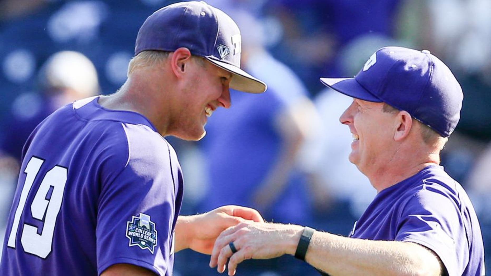 TCU's Luken Baker, left, celebrates with coach Jim Schlossnagle, right, following an NCAA men's College World Series baseball game against Texas Tech in Omaha, Neb., Sunday, June 19, 2016. Baker hit a go-ahead three-run home run in the top of the ninth and TCU won 5-3. (AP Photo/Nati Harnik)