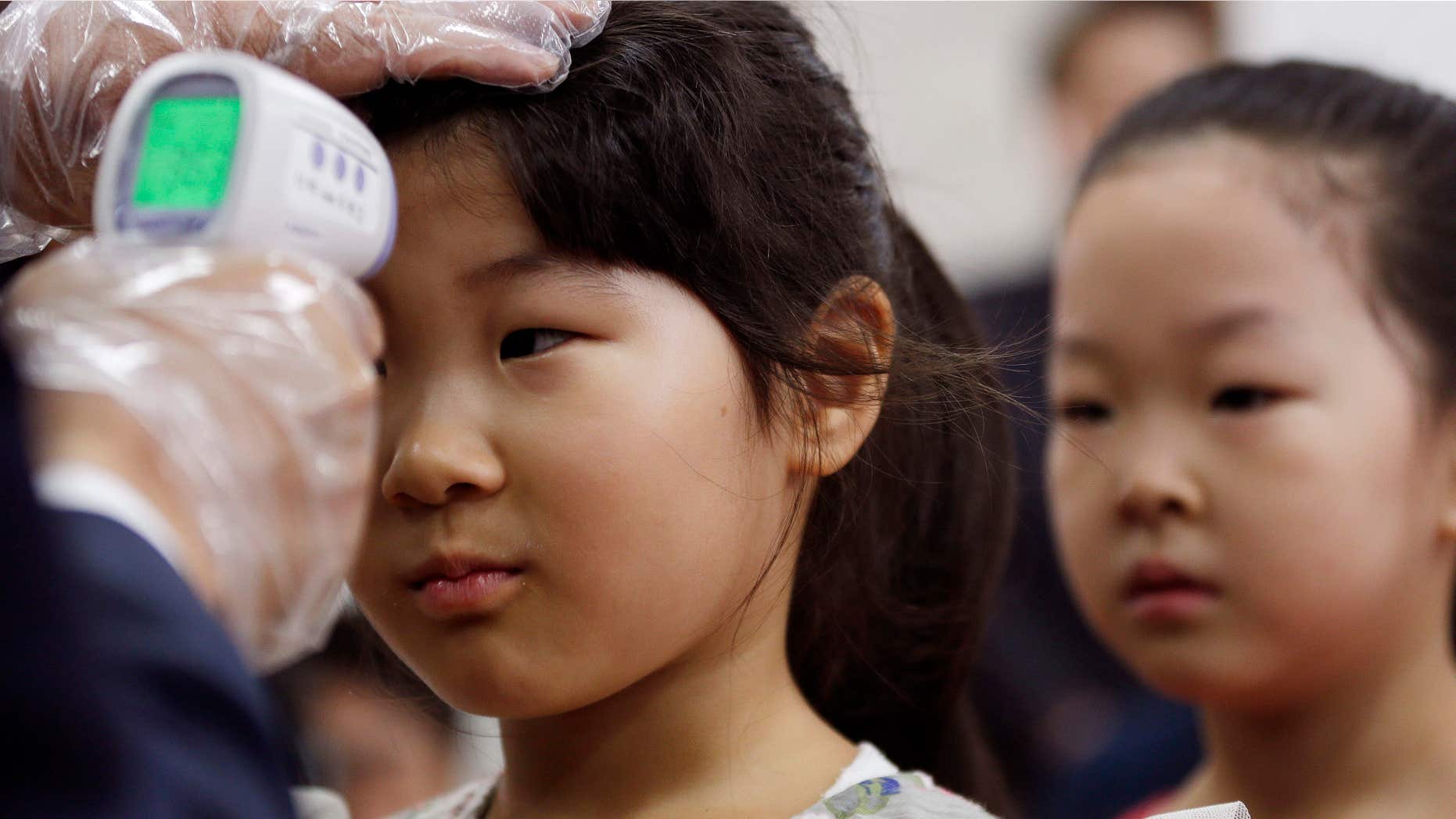 June 17, 2015: An unidentified student is checked her temperature as a precaution against MERS (Middle East Respiratory Syndrome) at Gwanghui Elementary School in Seoul, South Korea