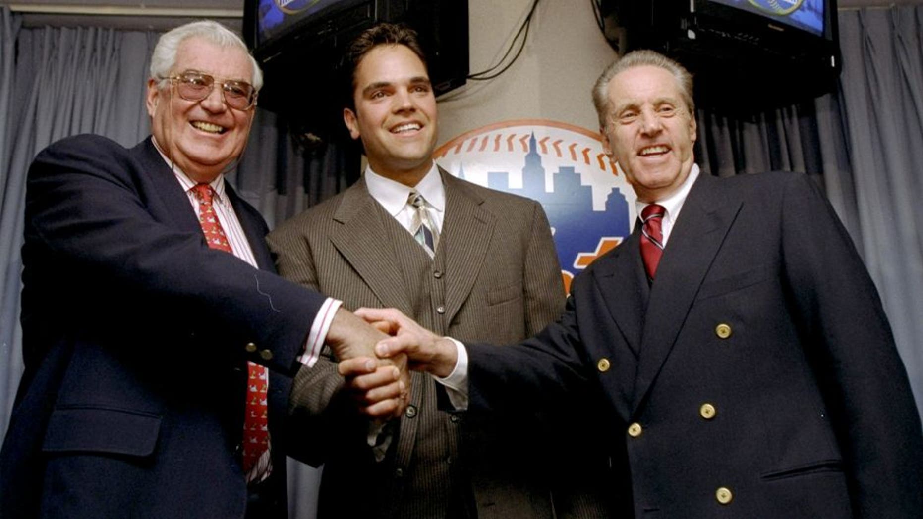 26 Oct 1998: Mike Piazza of the New York Mets shakes hands with Mets Owners Fred Wilpon (R) and Nelson Doubleday (L) during a Press Conference in New York City, New York. Mandatory Credit: Jamie Squire /Allsport