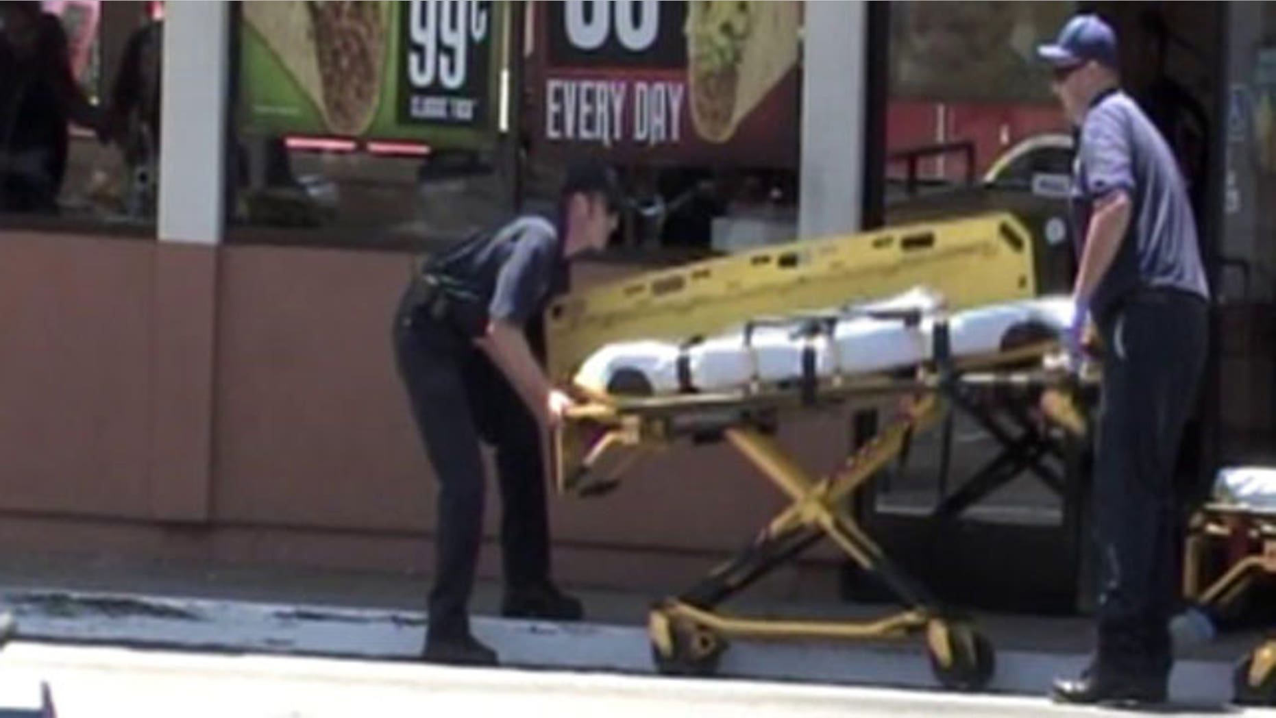 June 19: Emergency medical technicians respond to victims as authorities investigate a domestic shooting inside a Del Taco.