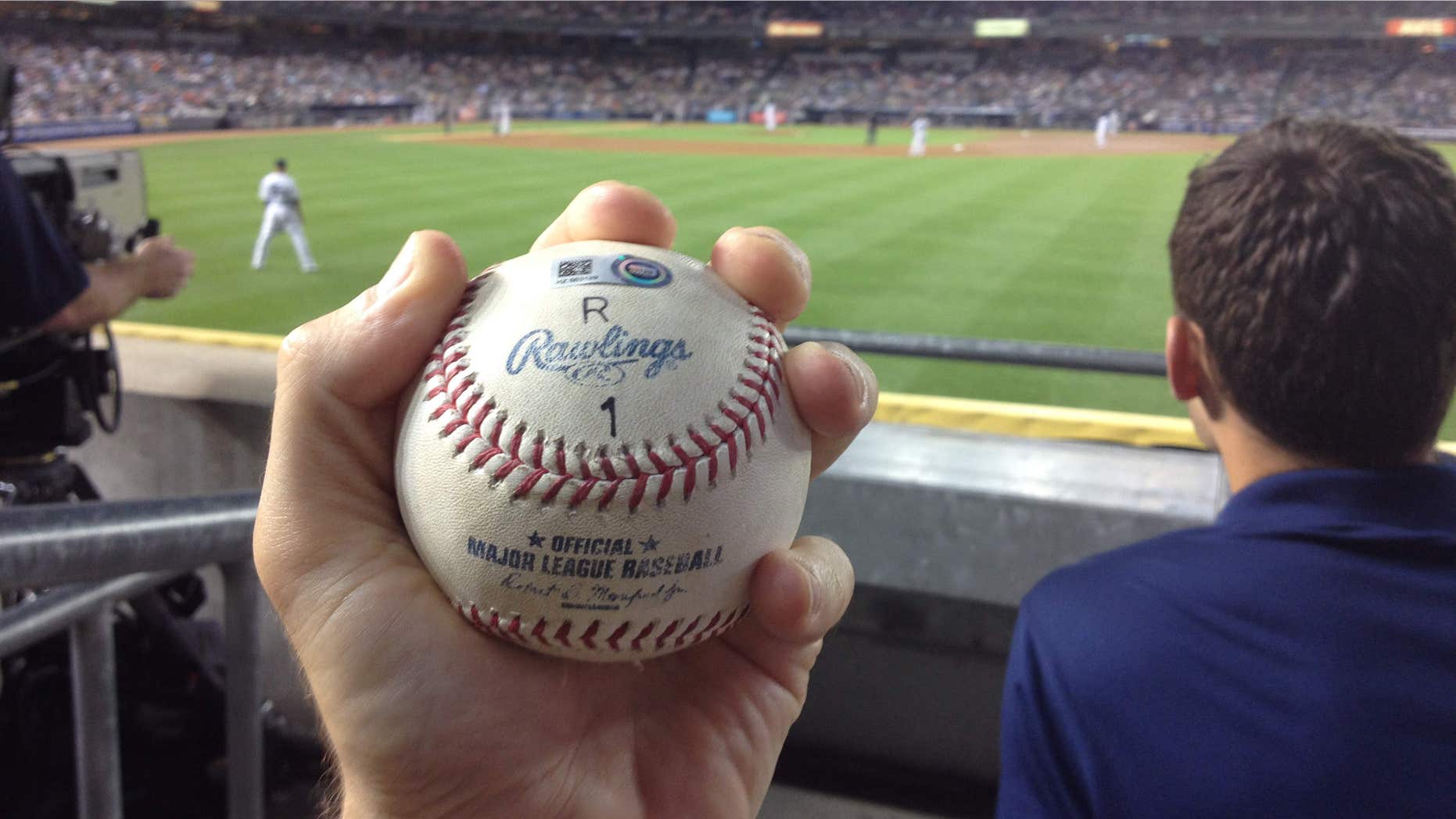 June 19, 2015: In a photo provided by Zack Hample, Zack Hample holds the baseball that New York Yankees' Alex Rodriguez hit on a home run for his 3,000th career hit, in the Yankees' baseball game against the Detroit Tigers.