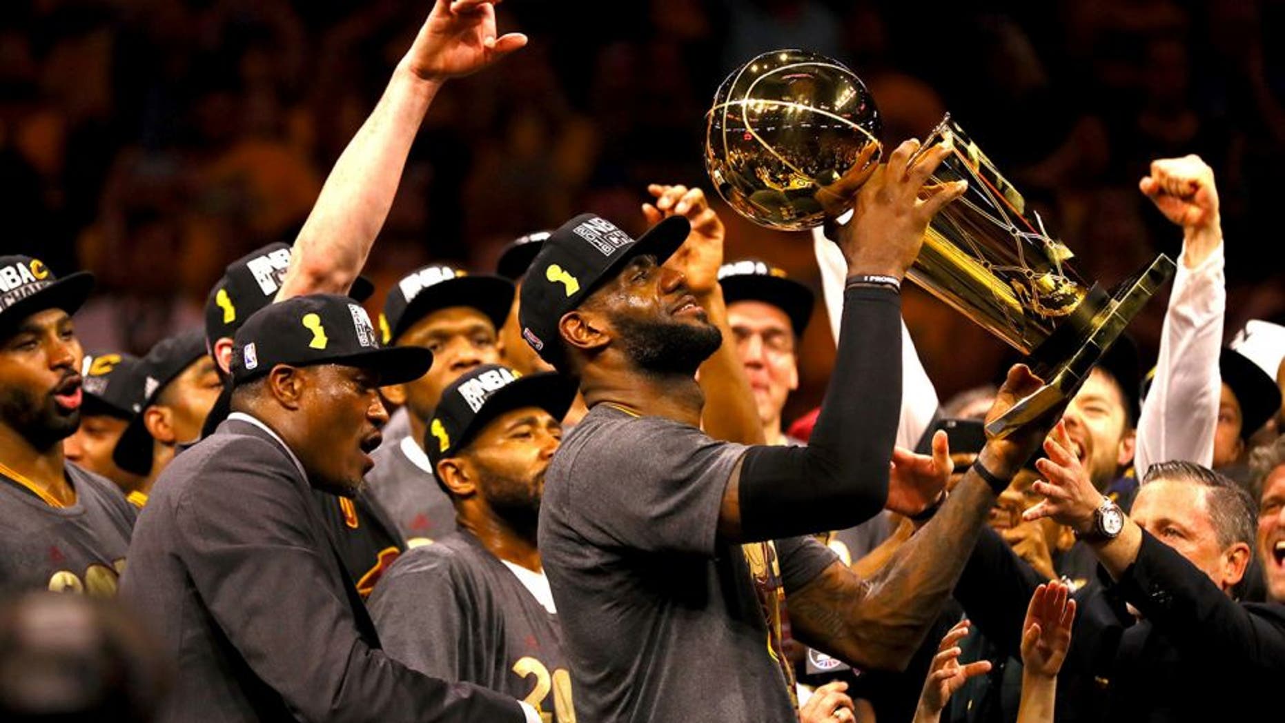 OAKLAND, CA - JUNE 19: LeBron James #23 of the Cleveland Cavaliers holds the Larry O'Brien Championship Trophy after defeating the Golden State Warriors 93-89 in Game 7 of the 2016 NBA Finals at ORACLE Arena on June 19, 2016 in Oakland, California. NOTE TO USER: User expressly acknowledges and agrees that, by downloading and or using this photograph, User is consenting to the terms and conditions of the Getty Images License Agreement. (Photo by Ezra Shaw/Getty Images)