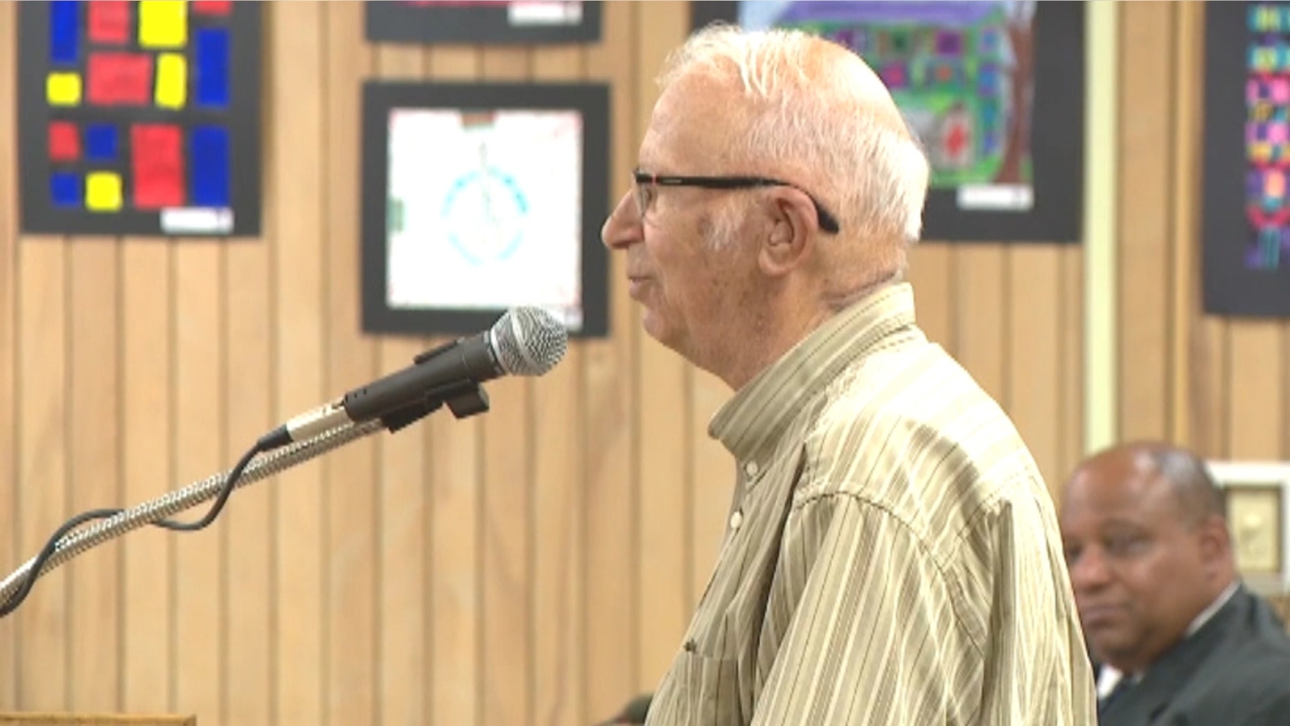 Robert Quincel, 87, receives his honorary high school diploma at a recent board meeting.