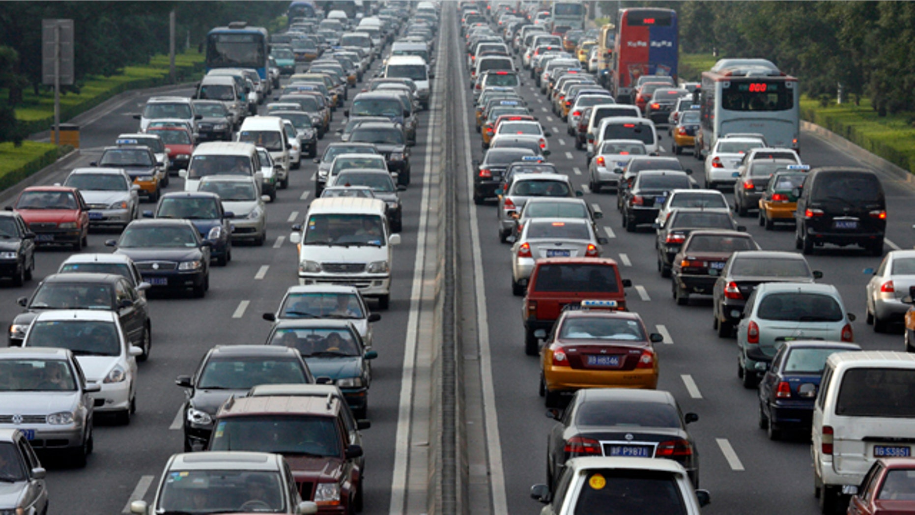 Vehicles wait during a traffic jam along a major thoroughfare in Beijing August 10, 2007. The Chinese capital will hold a test drill for keeping cars off the road during its 2008 Olympic Games, a crucial hurdle for the city beset by pollution and traffic jams, officials announced on Friday. Between Aug. 17 and 20, about 1.3 million of the city's 3 million vehicles will be ordered off the streets each day depending on whether licence plates end in an odd or even number. REUTERS/Claro Cortes IV (CHINA)