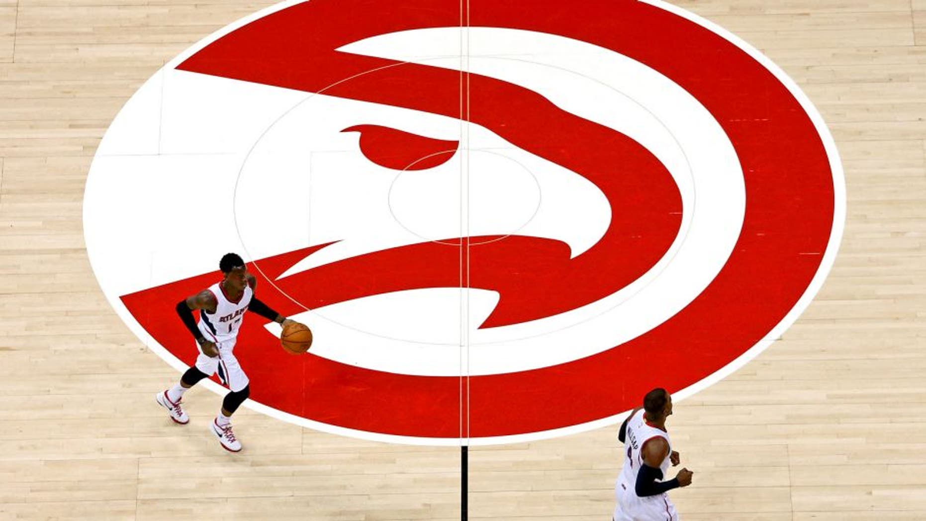 Mar 27, 2015; Atlanta, GA, USA; Atlanta Hawks guard Dennis Schroder (17) and forward Paul Millsap (4) cross the Atlanta Hawks logo in the first quarter of their game against the Miami Heat at Philips Arena. Mandatory Credit: Jason Getz-USA TODAY Sports