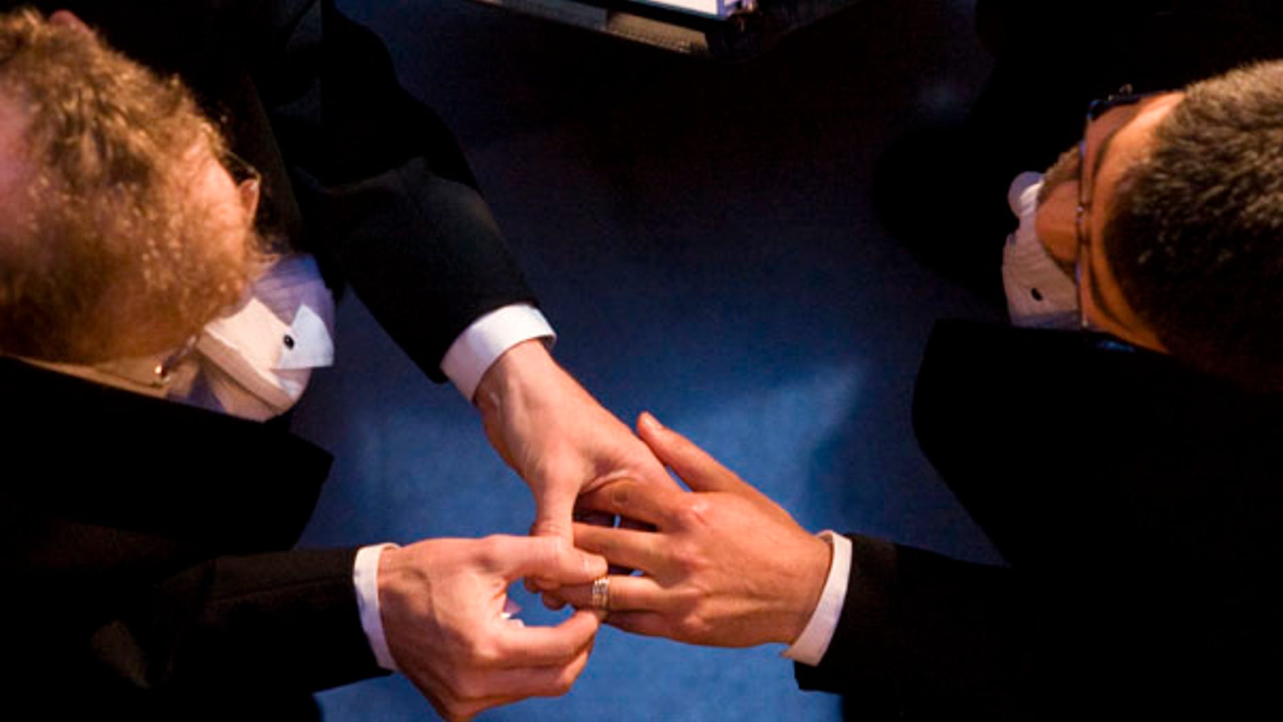 FILE - In this file photo taken June 17, 2008, John Lewis, left, puts a wedding ring on the hand of Stuart Gaffney, both of San Francisco, as they exchange marriage vows at City Hall in San Francisco. County clerk offices opened their doors June 17, 2008, to hundreds of gay and lesbian couples with appointments to secure marriage licenses and exchange vows on the first full day same-sex nuptials were legal throughout California. (AP Photo/Darryl Bush, File)