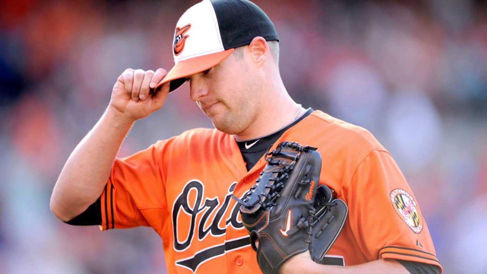 Baltimore Orioles starting pitcher Bud Norris touches the brim of his hat as he walks back to the dugout after he was pulled from the baseball game against the Toronto Blue Jays during the seventh inning Saturday, June 14, 2014, in Baltimore. The Orioles won 3-2. (AP Photo/Nick Wass)