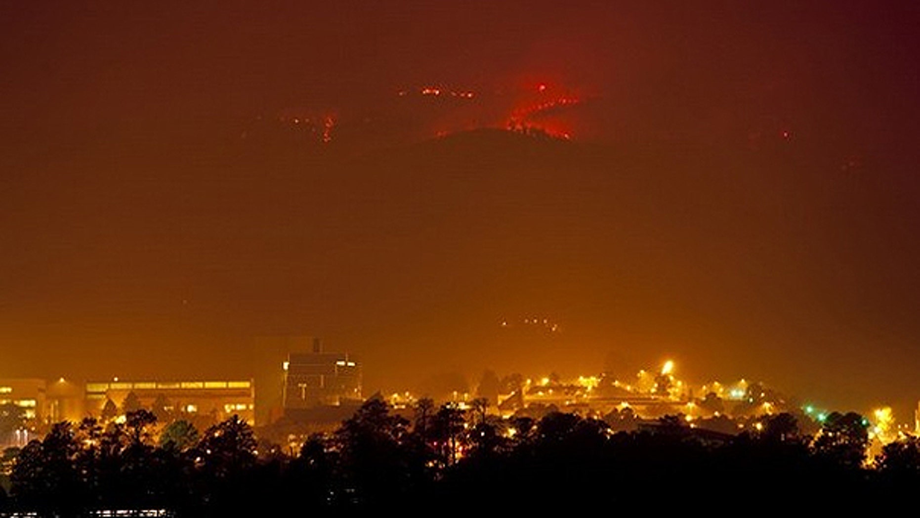 June 27: Flames from the Las Conchas fire burn in the hills above Los Alamos National Laboratory, a nuclear facility.