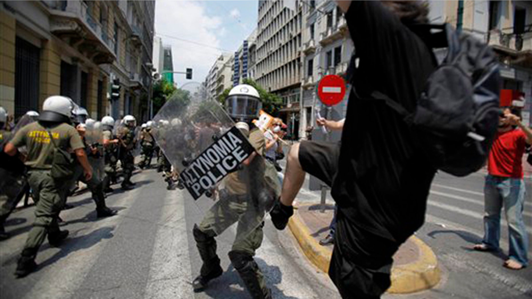A demonstrator kicks a riot policeman during clashes in central Athens on Tuesday, June 29, 2010. Some 16,000 people took part in two separate demonstrations, the second of which turned violent as stone-throwing youths fought with riot police. Public services shut down across Greece Tuesday as workers walked off the job in a new nationwide general strike that disrupted public transport, left hospitals operating on emergency staff and pulled all news broadcasts off the air. (AP Photo)