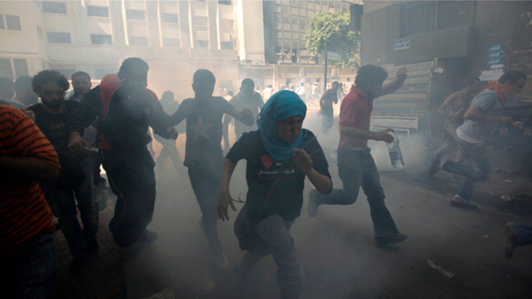 June 29: Egyptian protesters run to avoid tear gas during clashes with security forces at Tahrir Square in Cairo, Egypt.