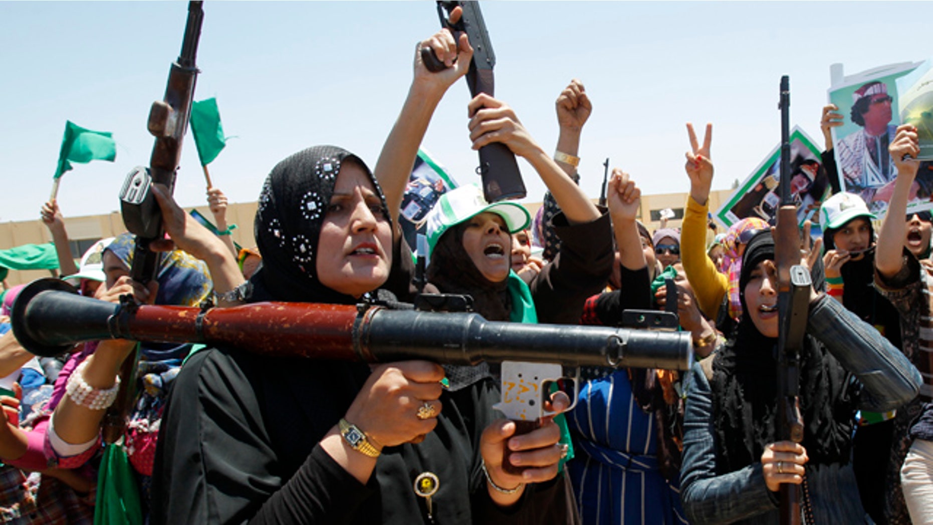 June 28: In this photo taken on a government-organized tour, Libyan women chant pro-Muammar al-Qaddafi slogans as they attend a weapons training session in the town of Bani Walid, Libya.