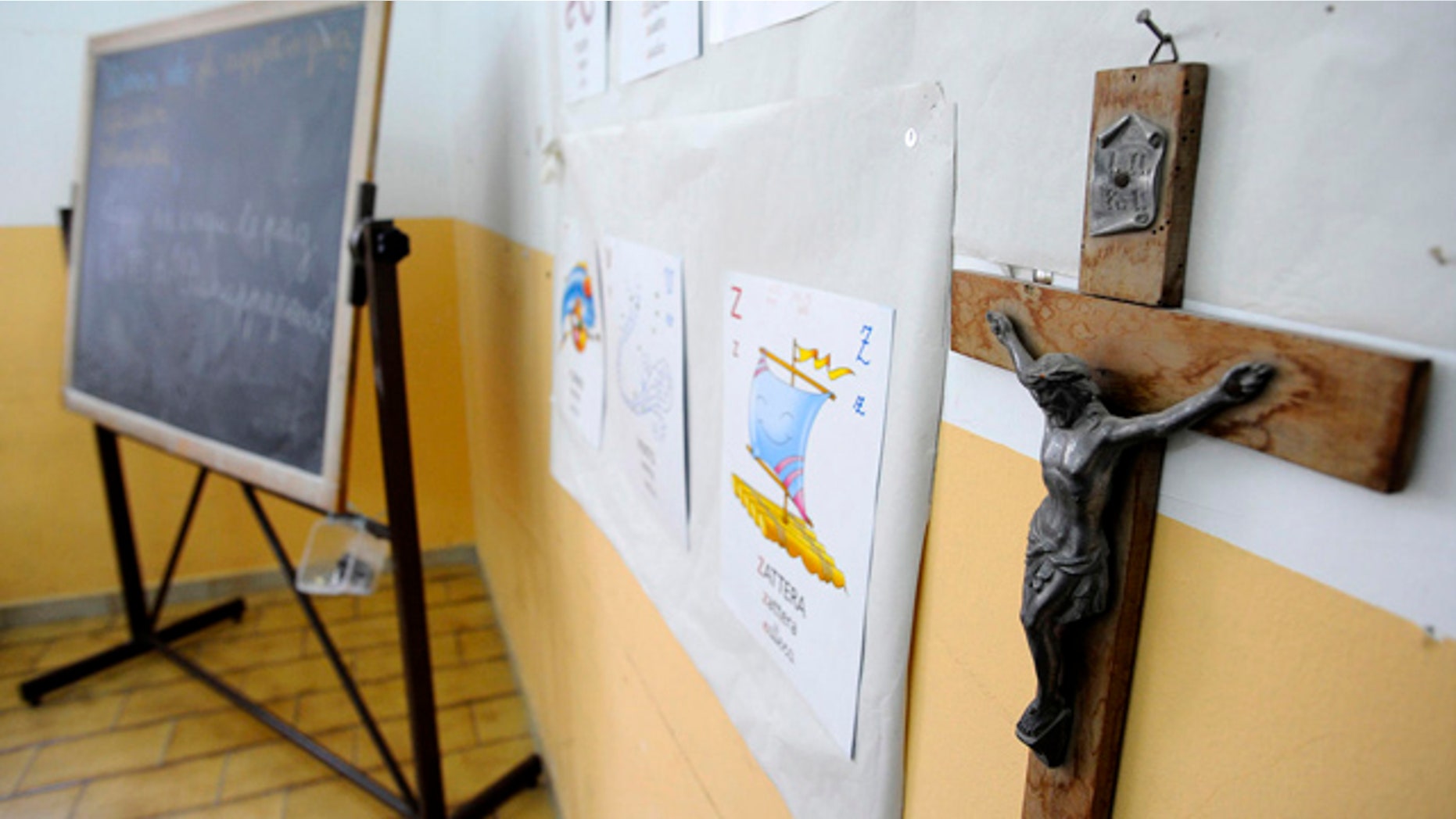 A crucifix hangs from the wall of a Naples elementary school's classroom, Italy, Tuesday, Nov. 3, 2009. Europe's court of human rights ruled Tuesday the display of crucifixes in Italian public schools violates religious and education freedoms under the continent's rights convention. The ruling, which could force a Europe-wide review of the use of religious symbols in government-run schools, rejected arguments by Italy's government that the crucifix was a national symbol of culture, history and identity, tolerance and secularism. A seven-judge panel sided with a complaint filed by Soile Lautsi, a parent of two children, who claimed public schools in her northern Italian town eight years ago refused to remove the Roman Catholic symbols from classrooms. The ruling awarded euro 5,000 (US$ 7,390) in damages to Lautsi, which the Italian government will pay her. (AP Photo/Salvatore Laporta)