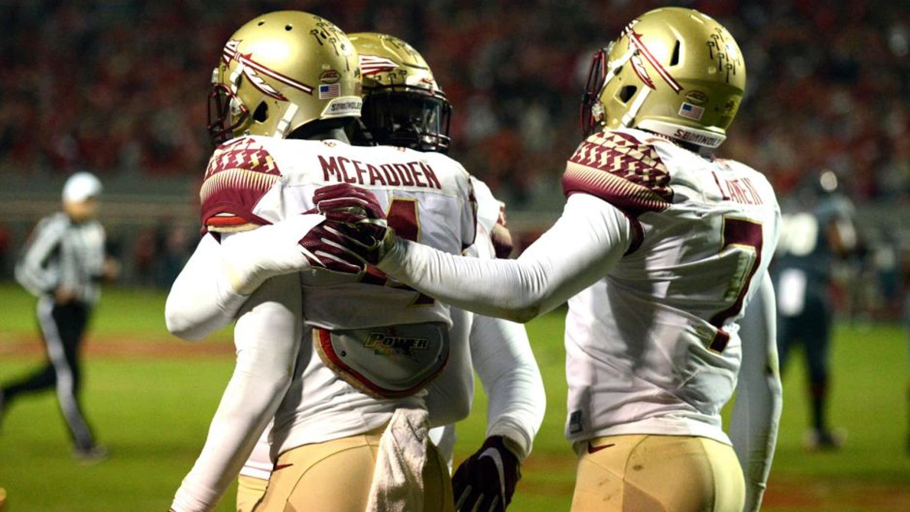 Nov 5, 2016; Raleigh, NC, USA; Florida State Seminoles defensive back Tarvarus McFadden (4) is congratulated by teammates after an interception during the first half against the North Carolina State Wolfpack at Carter Finley Stadium. Mandatory Credit: Rob Kinnan-USA TODAY Sports