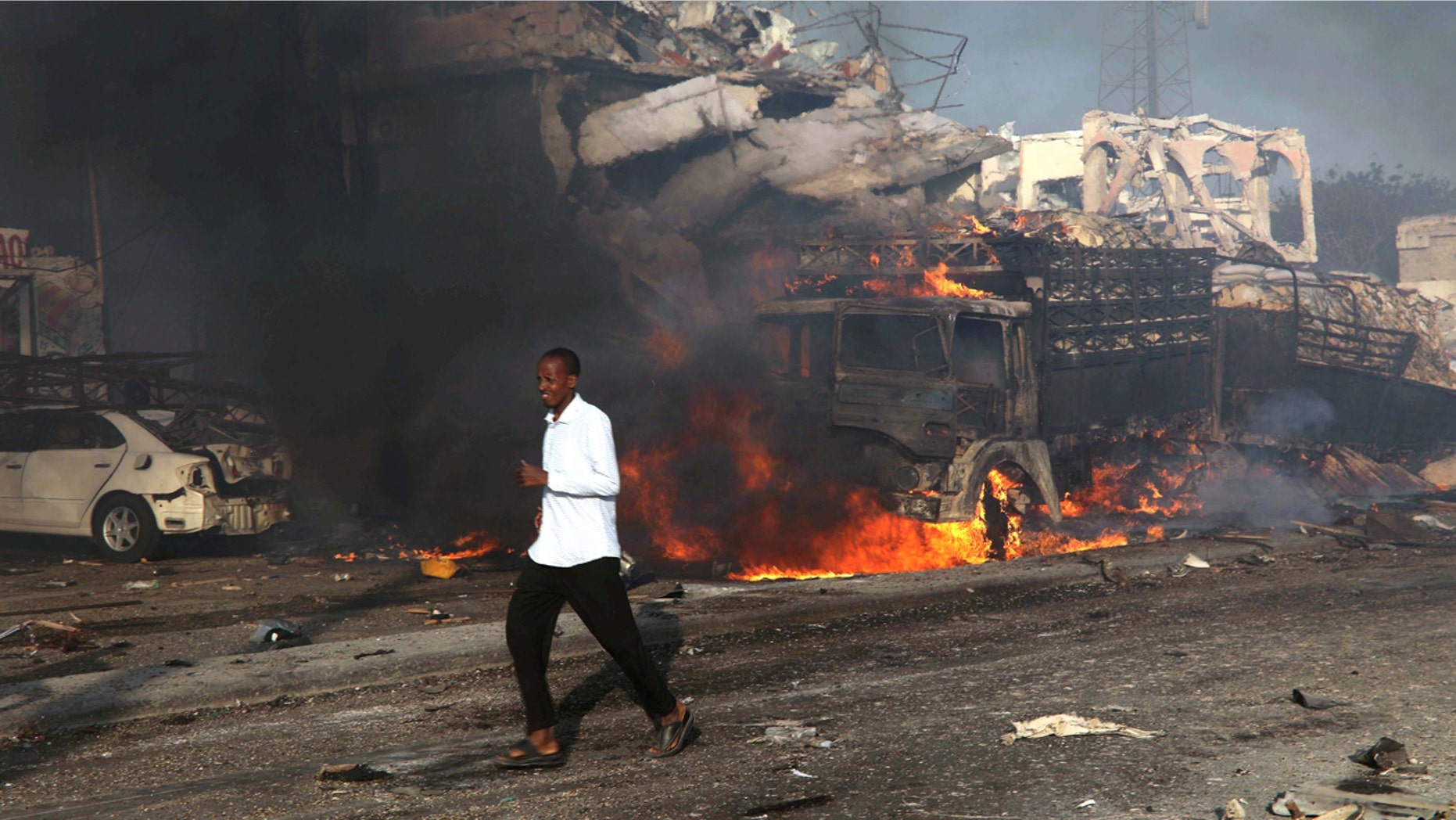 FILE: A man runs past the scene of an explosion in the street in Hodan district of Mogadishu