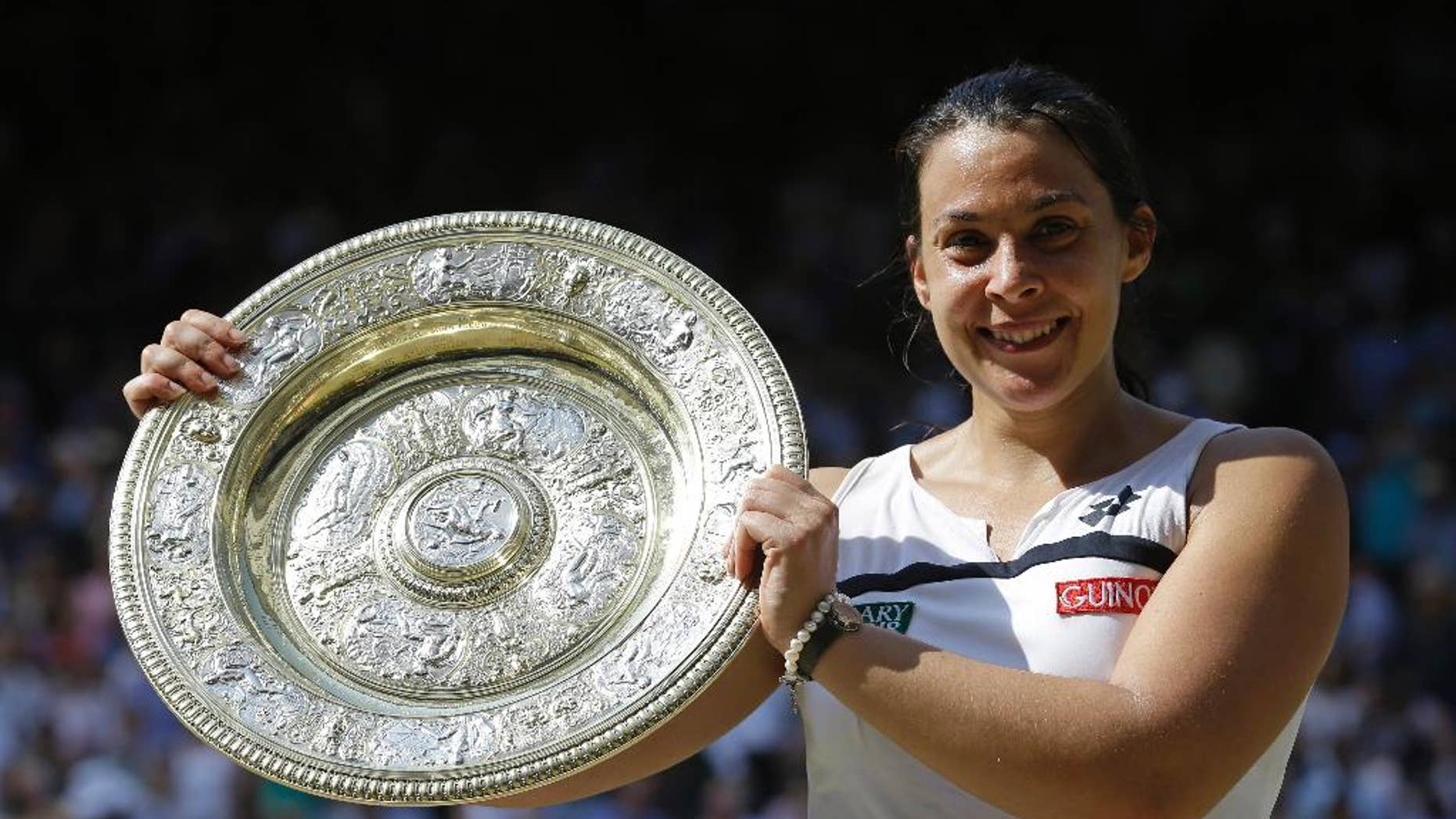 FILE - A Saturday, July 6, 2013 file photo showing Marion Bartoli of France smiling as she holds the trophy after winning the Women's singles final match against Sabine Lisicki of Germany at the All England Lawn Tennis Championships in Wimbledon, London. Three years after winning the title at Wimbledon, Marion Bartoli said she has contracted an unknown virus and her life is an "absolute nightmare." The 31-year-old Frenchwoman is now extremely thin and said it's because she is ill. (AP Photo/Anja Niedringhaus, File)