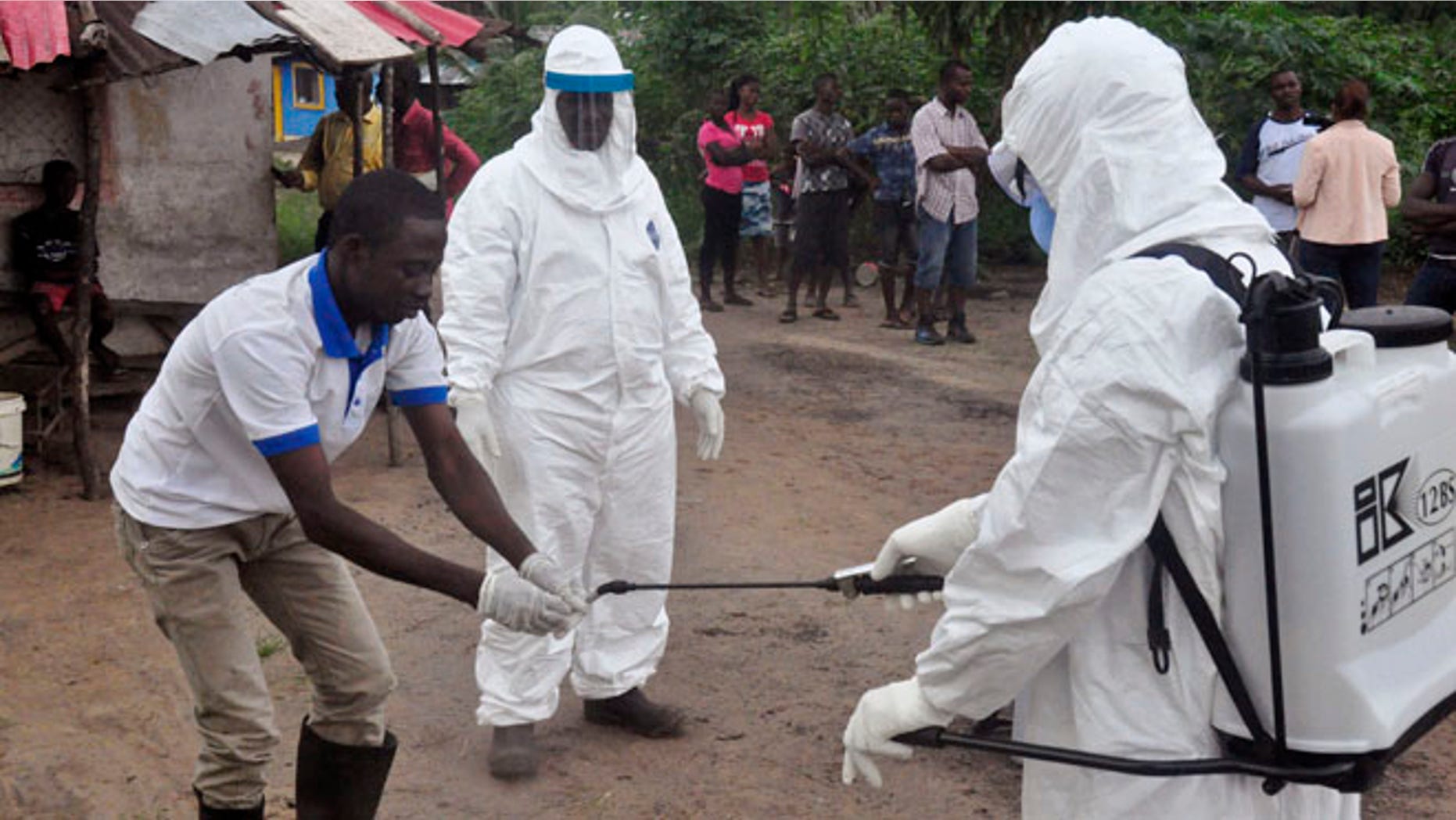 June 30, 2015: Health workers wash their hands after taking a blood specimen from a child to test for the Ebola virus in an area where a 17-year old boy died from the virus on the outskirts of Monrovia, Liberia.