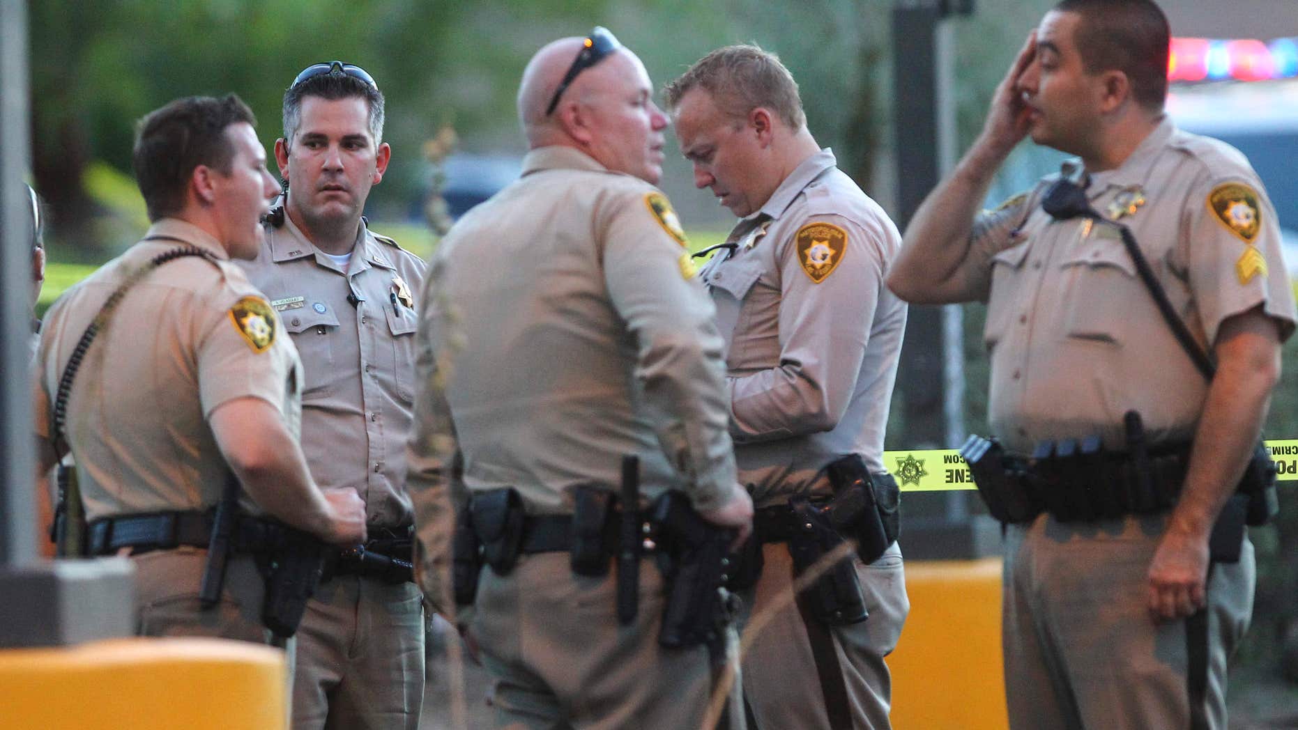 In this photo taken Wednesday, June 29, 2016, Las Vegas police investigate a homicide outside of a Walgreens at Lake Mead and Jones Boulevards in Las Vegas.